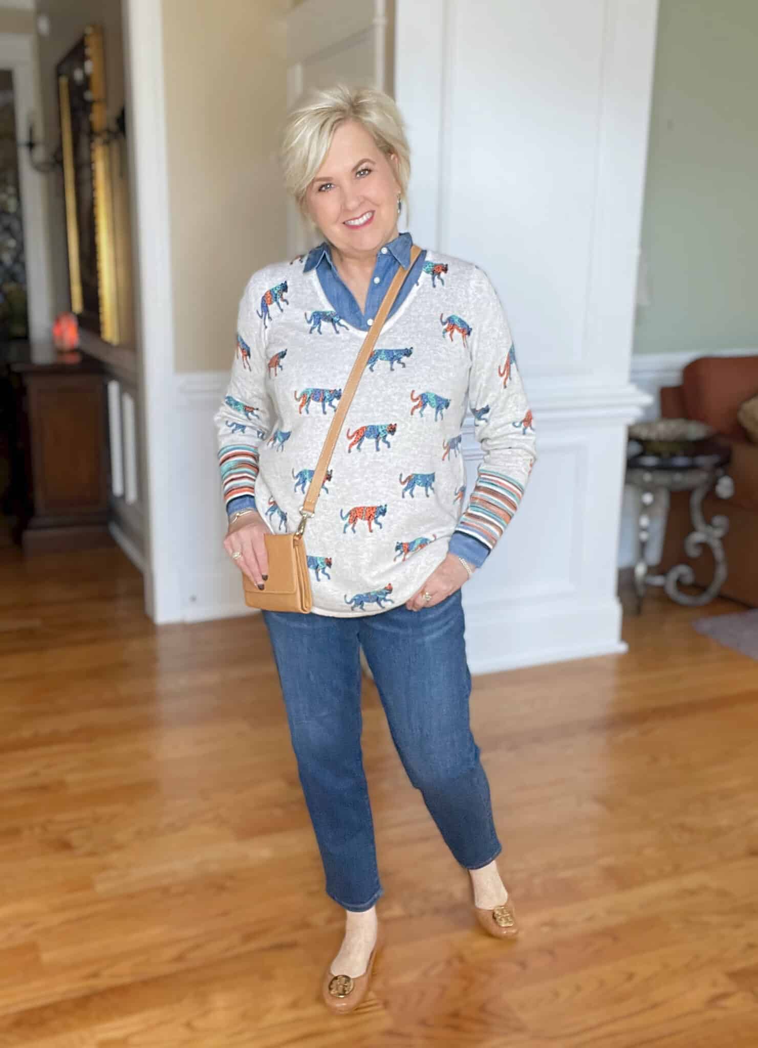 Over 40 Fashion Blogger, Tania Stephens is styling a chambray shirt under a bright leopard print sweater with tapered jeans and ballet flats