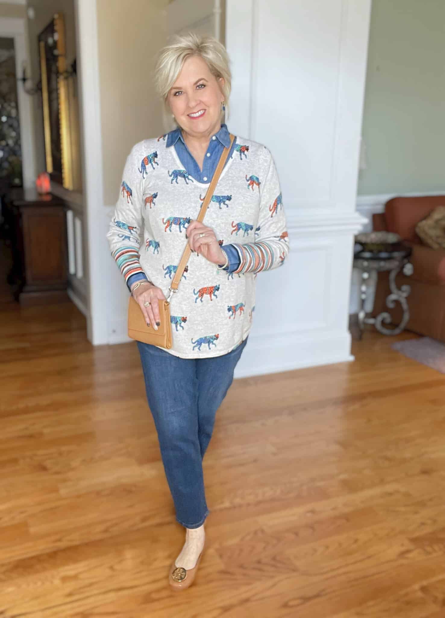 Over 40 Fashion Blogger, Tania Stephens is styling a chambray shirt under a bright leopard print sweater with tapered jeans