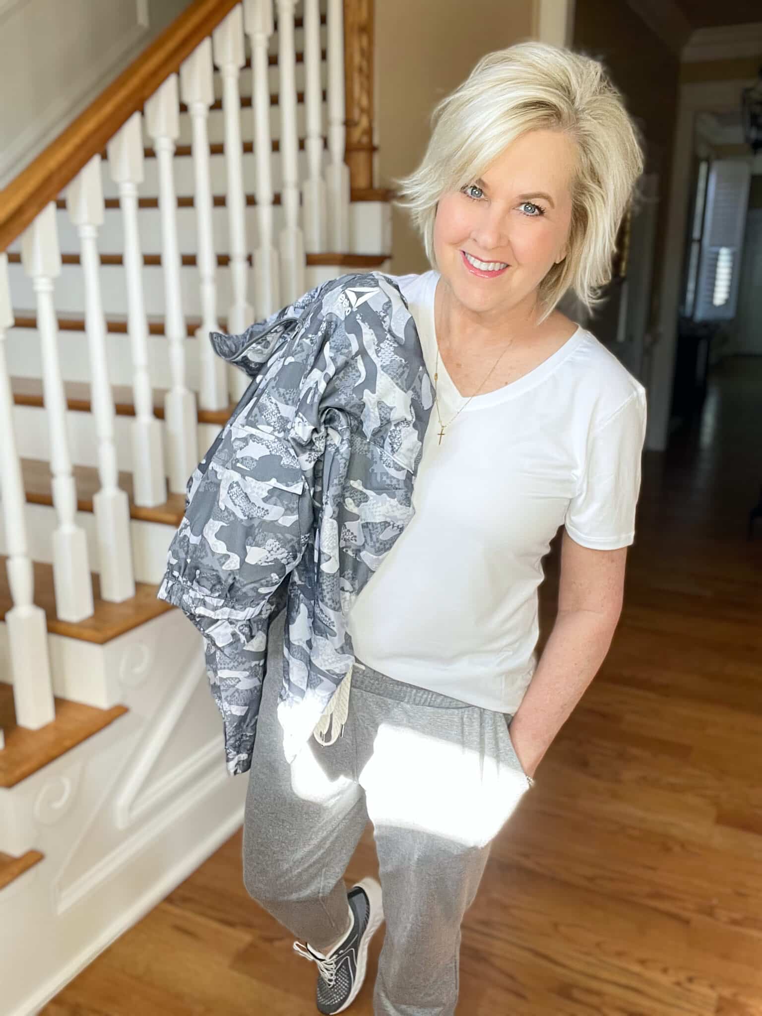 Over 40 Fashion Blogger, Tania Stephens is wearing a white v-neck t-shirt with a gray windbreaker