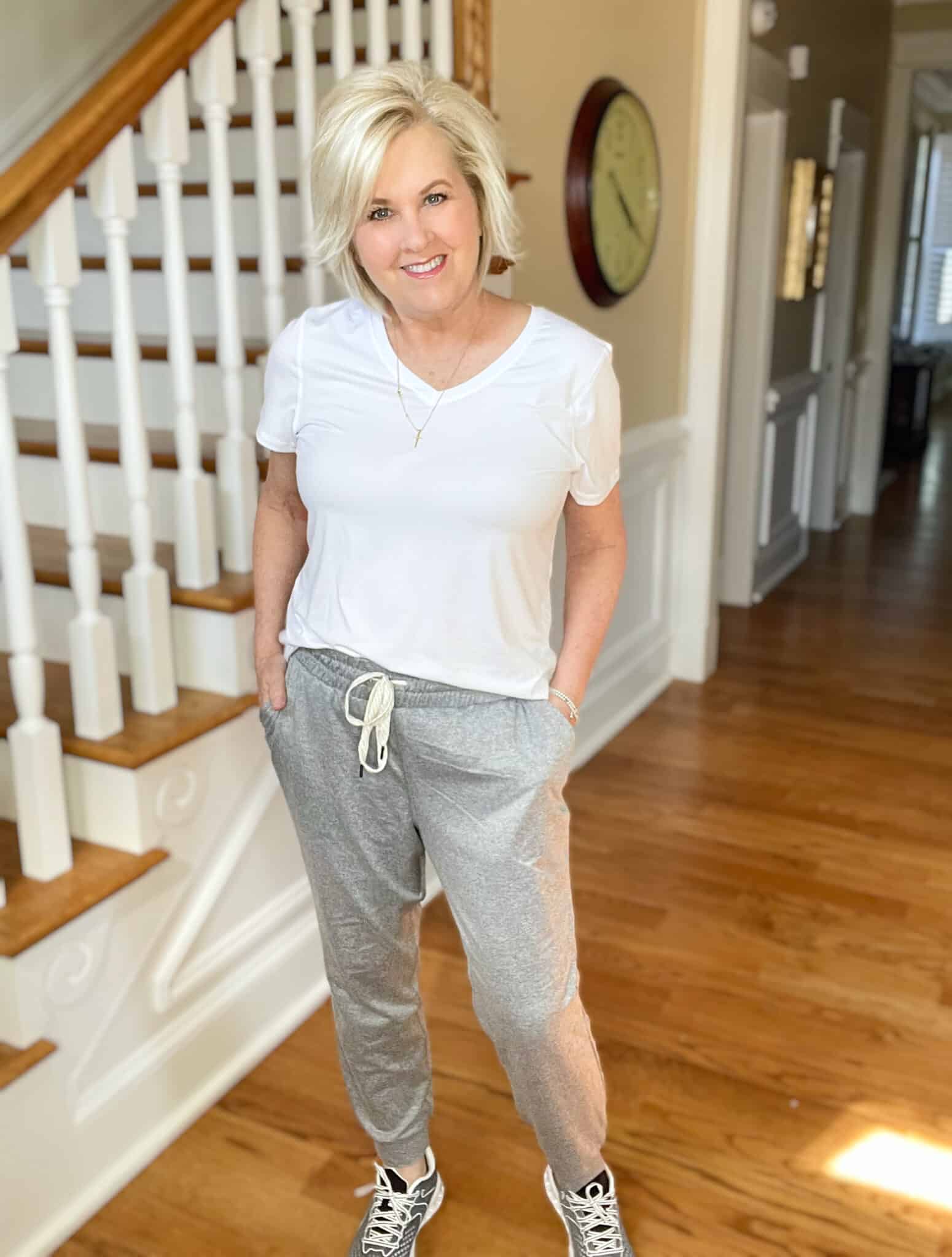 Over 40 Fashion Blogger, Tania Stephens is wearing a white v-neck t-shirt with gray joggers