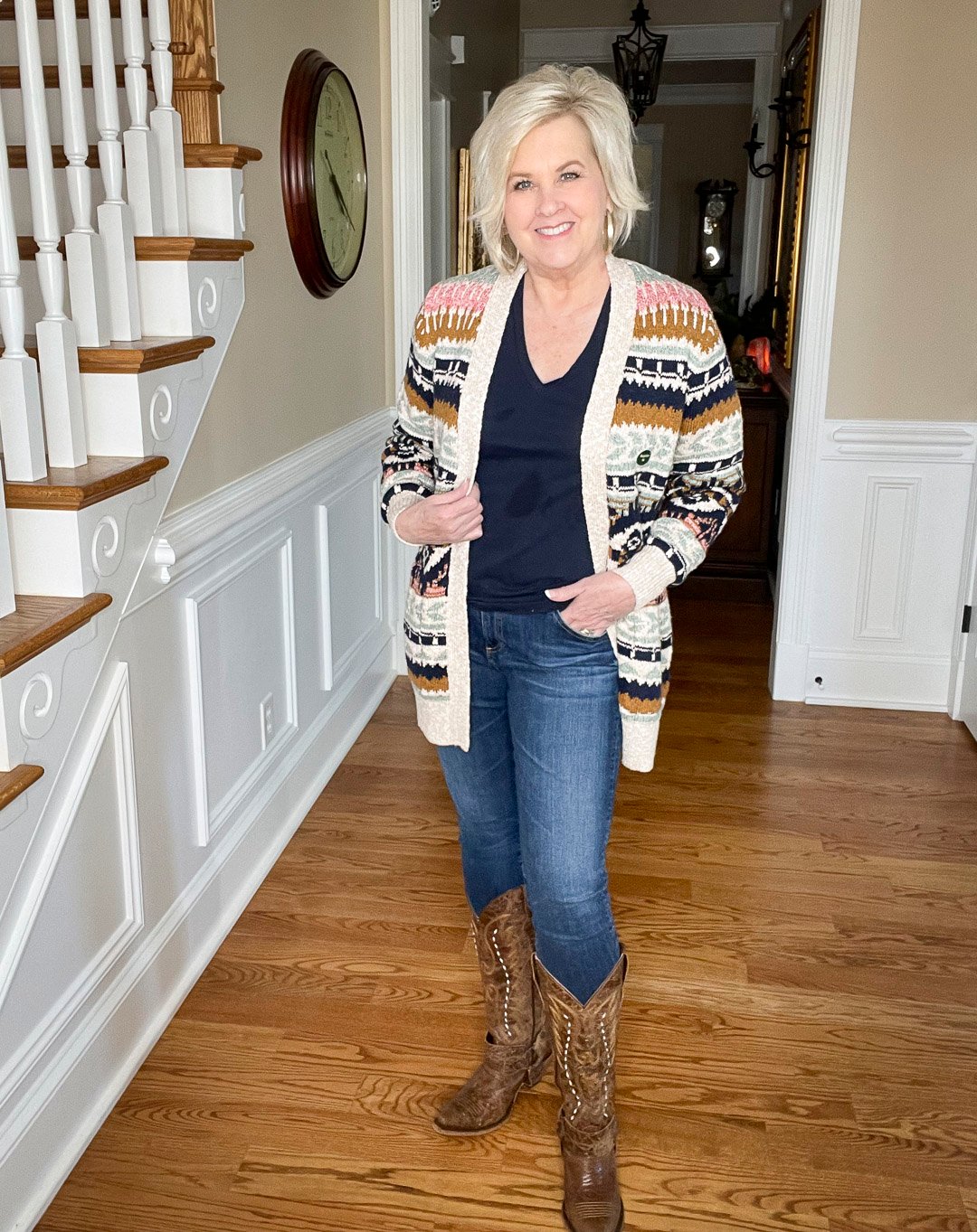 Over 40 Fashion Blogger, Tania Stephens is wearing a navy t-shirt and skinny jeans with a multi-colored striped cardigan and cowboy boots