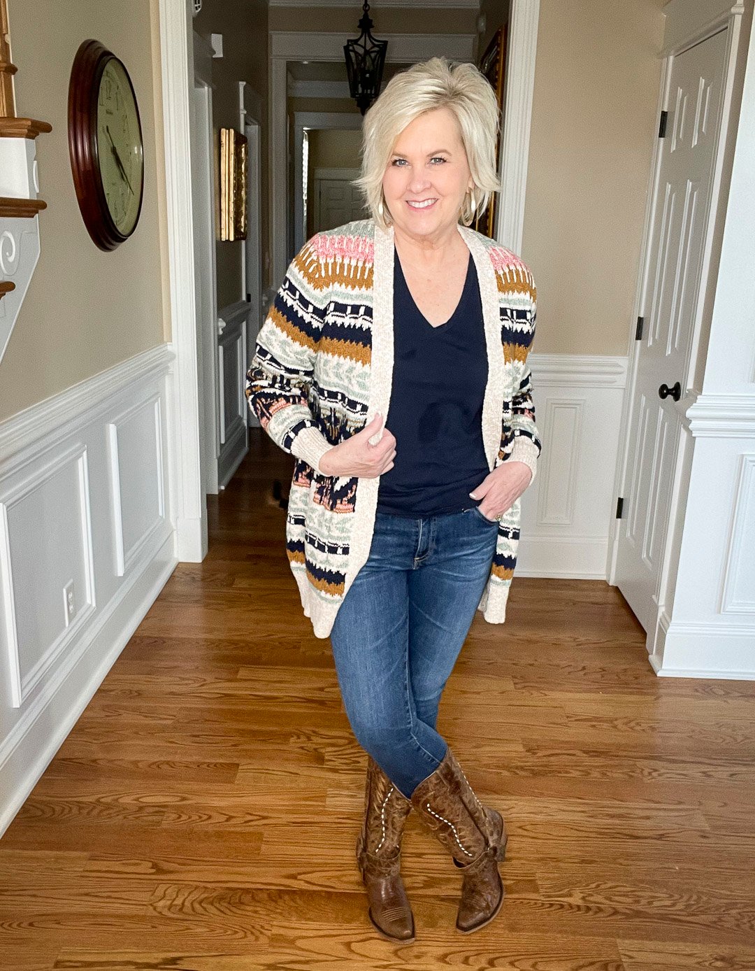 Over 40 Fashion Blogger, Tania Stephens is wearing a navy t-shirt and skinny jeans with a multi-colored striped cardigan and cowboy boots by Lane
