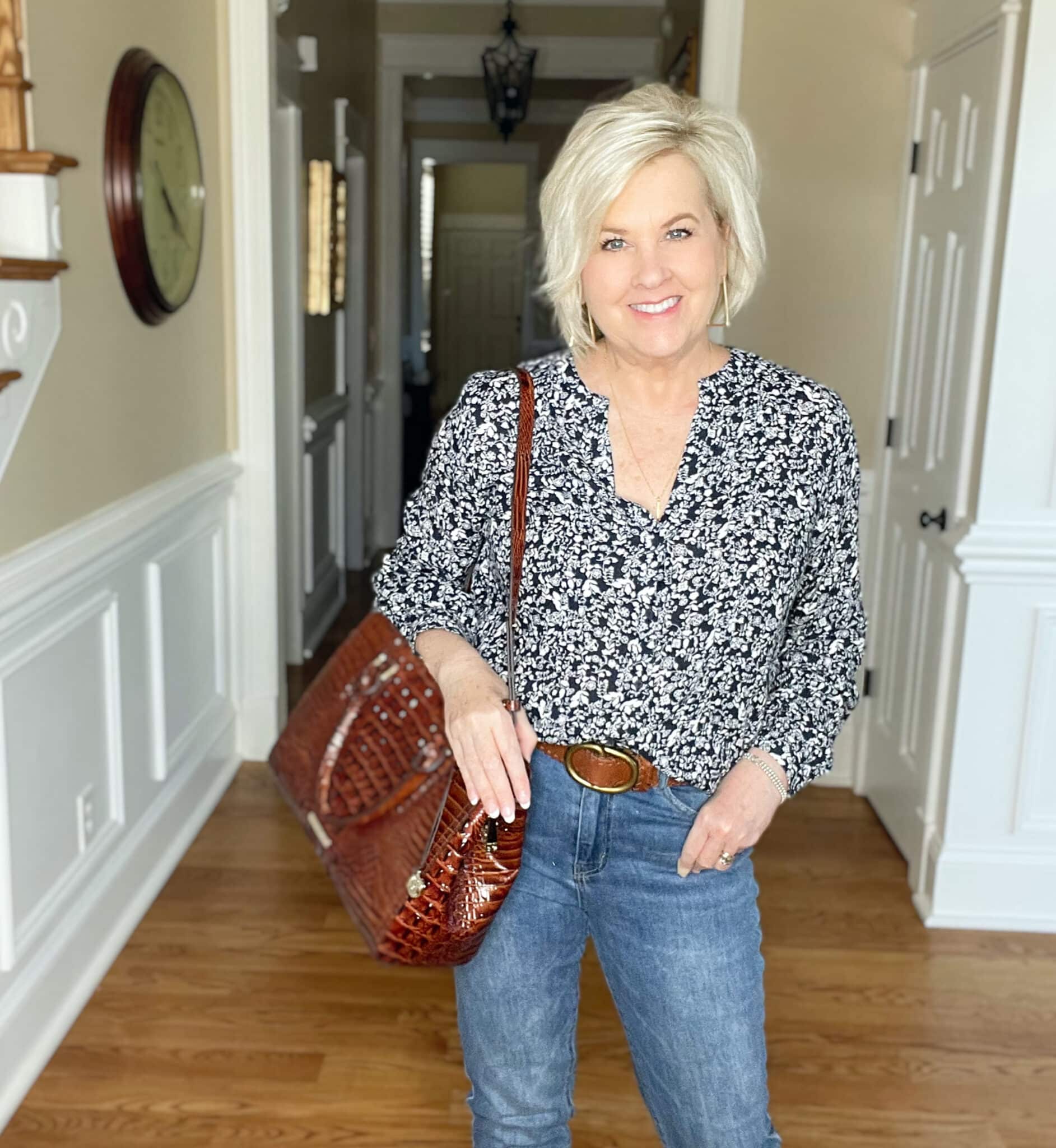 Over 40 Fashion Blogger, Tania Stephens is wearing a navy and white floral top and carrying a Brahmin handbag