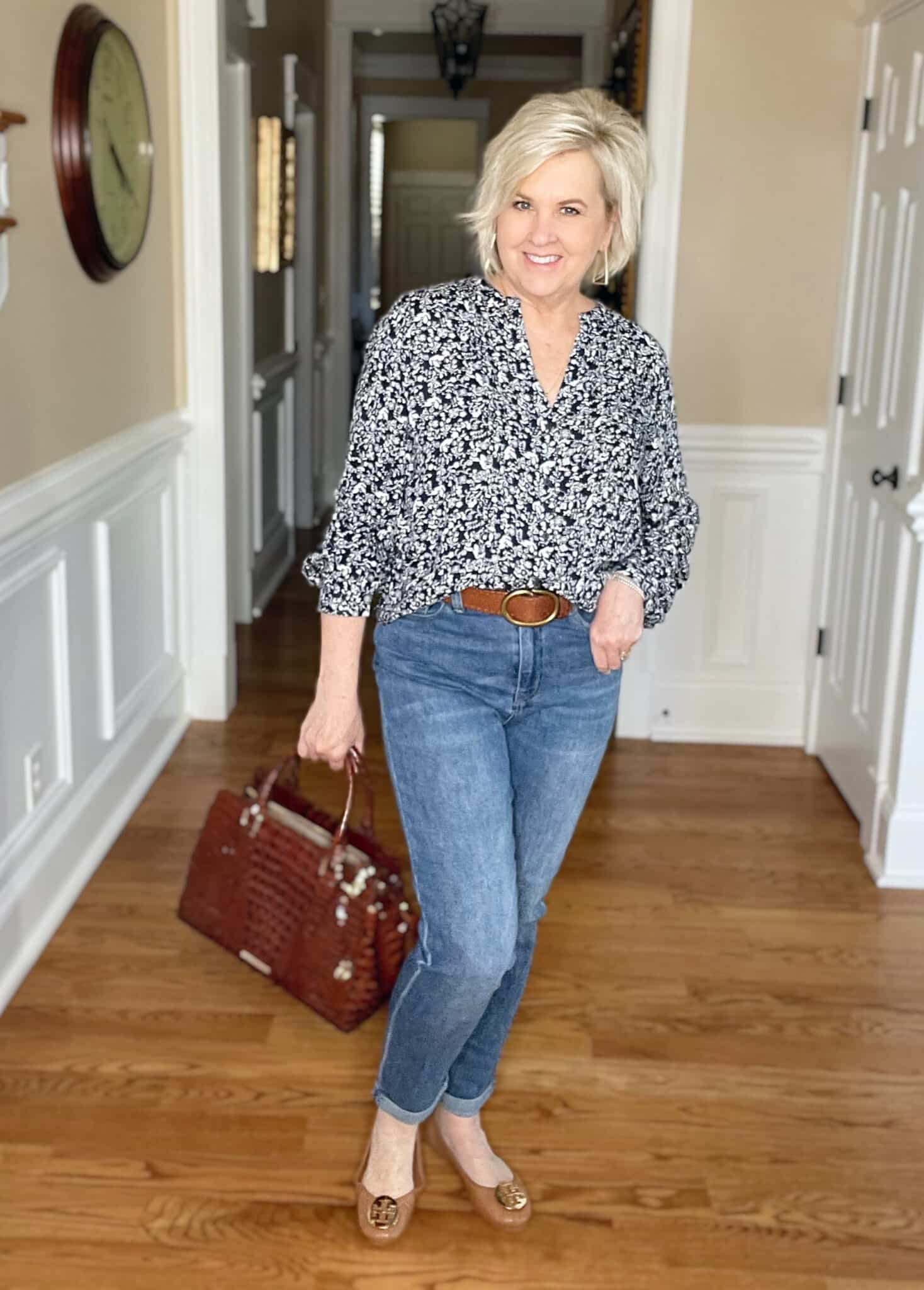 Over 40 Fashion Blogger, Tania Stephens is wearing a navy and white floral top, jeans, and Tory Burch flats