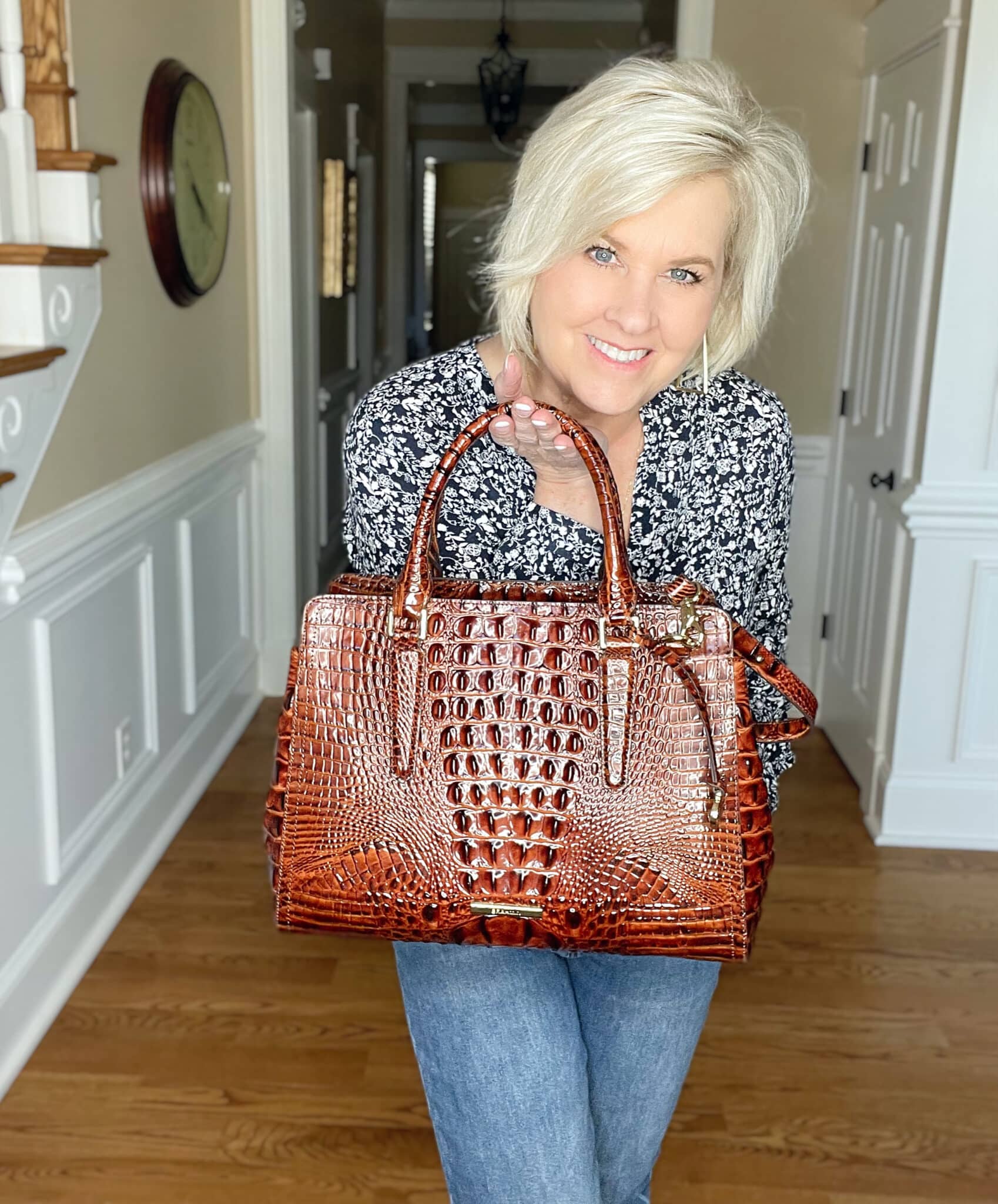Over 40 Fashion Blogger, Tania Stephens is wearing a navy and white floral top and carrying a Brahmin handbag