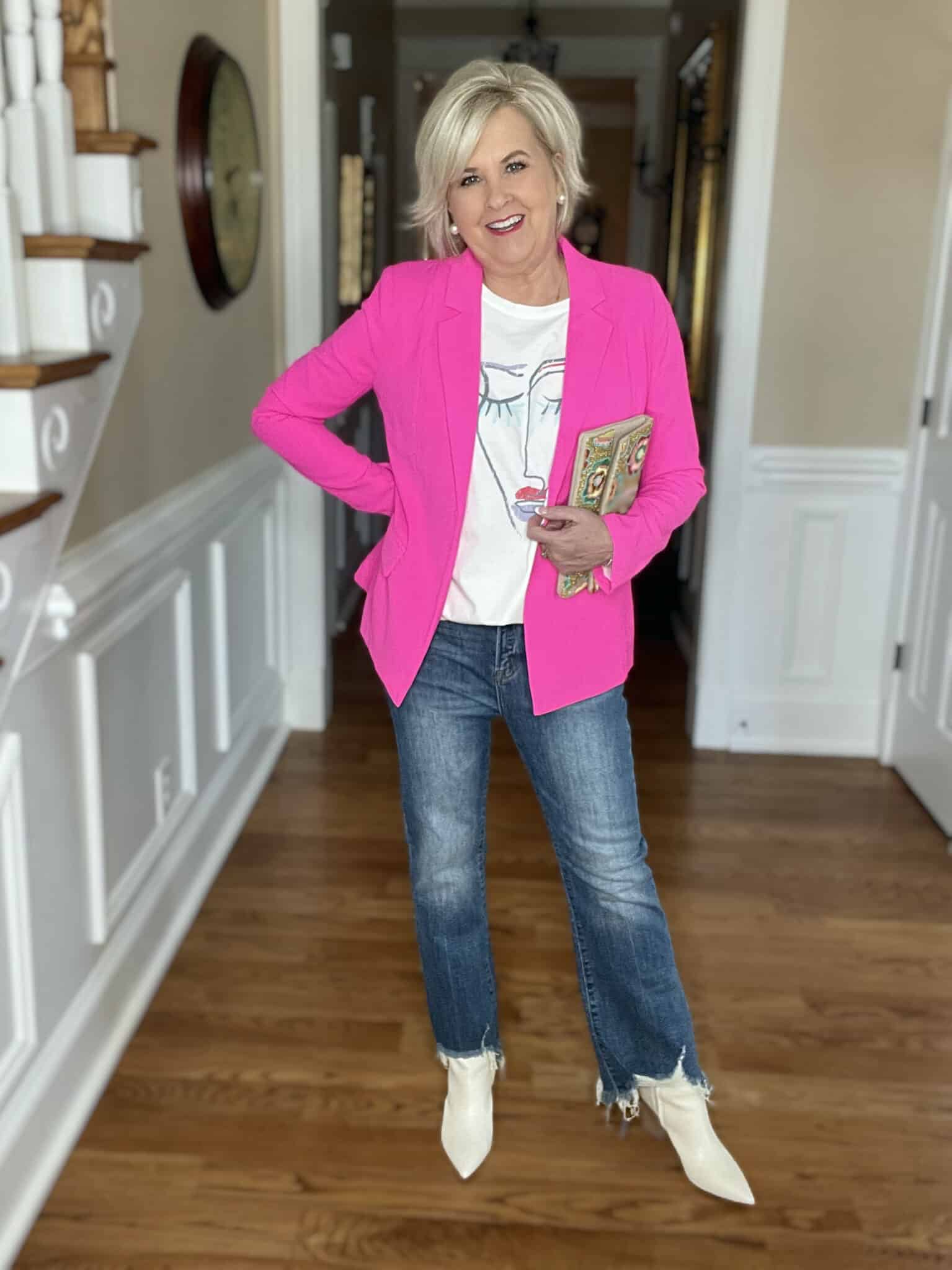 Over 40 Fashion Blogger, Tania Stephens is wearing a bright pink blazer, a graphic tee, and ripped hem jeans from Social Threads