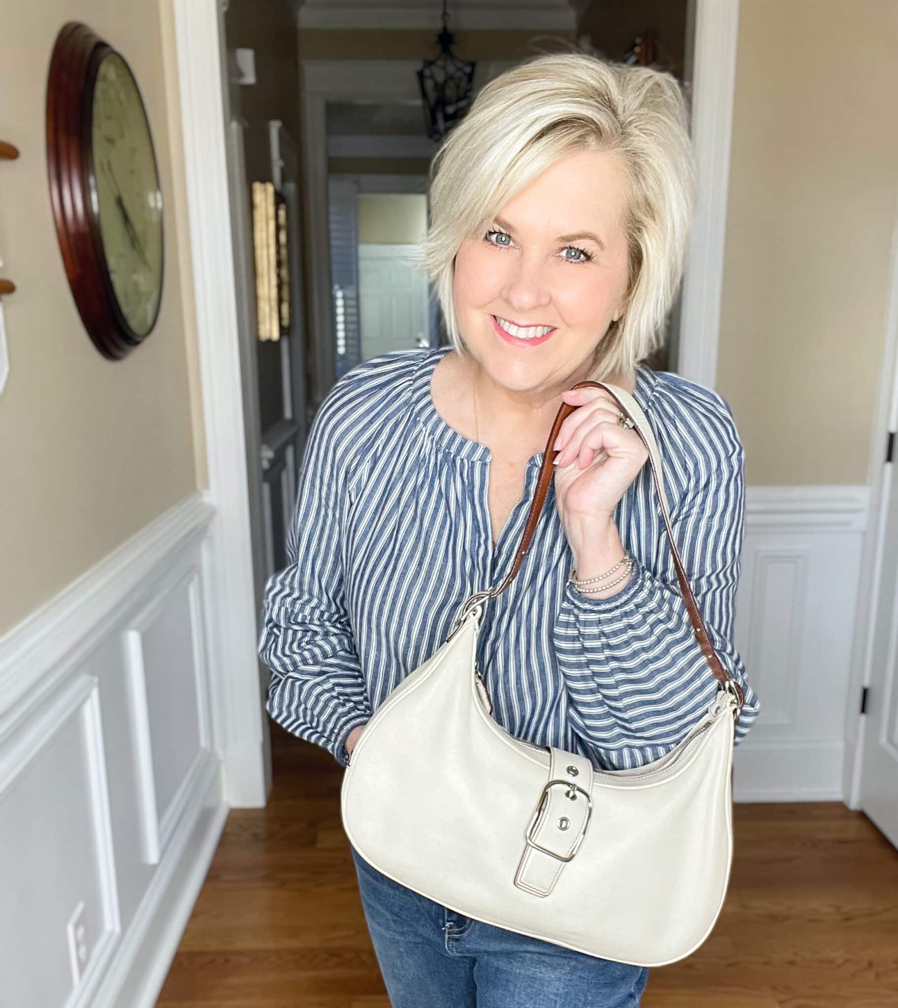 Over 40 Fashion Blogger, Tania Stephens is styling a striped shirt with an ivory Coach handbag