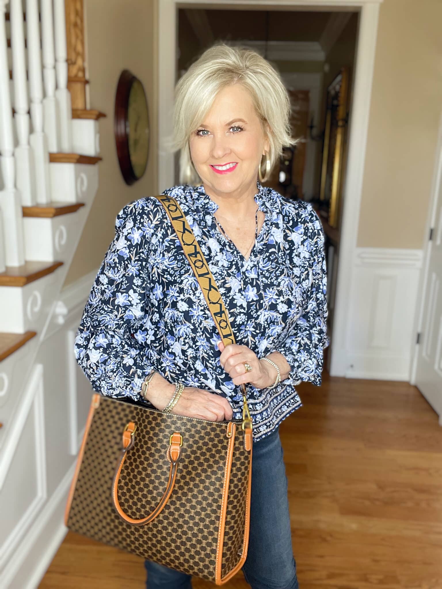 Over 40 Fashion Blogger, Tania Stephens is wearing a blue floral top from Walmart and a handbag from Amazon