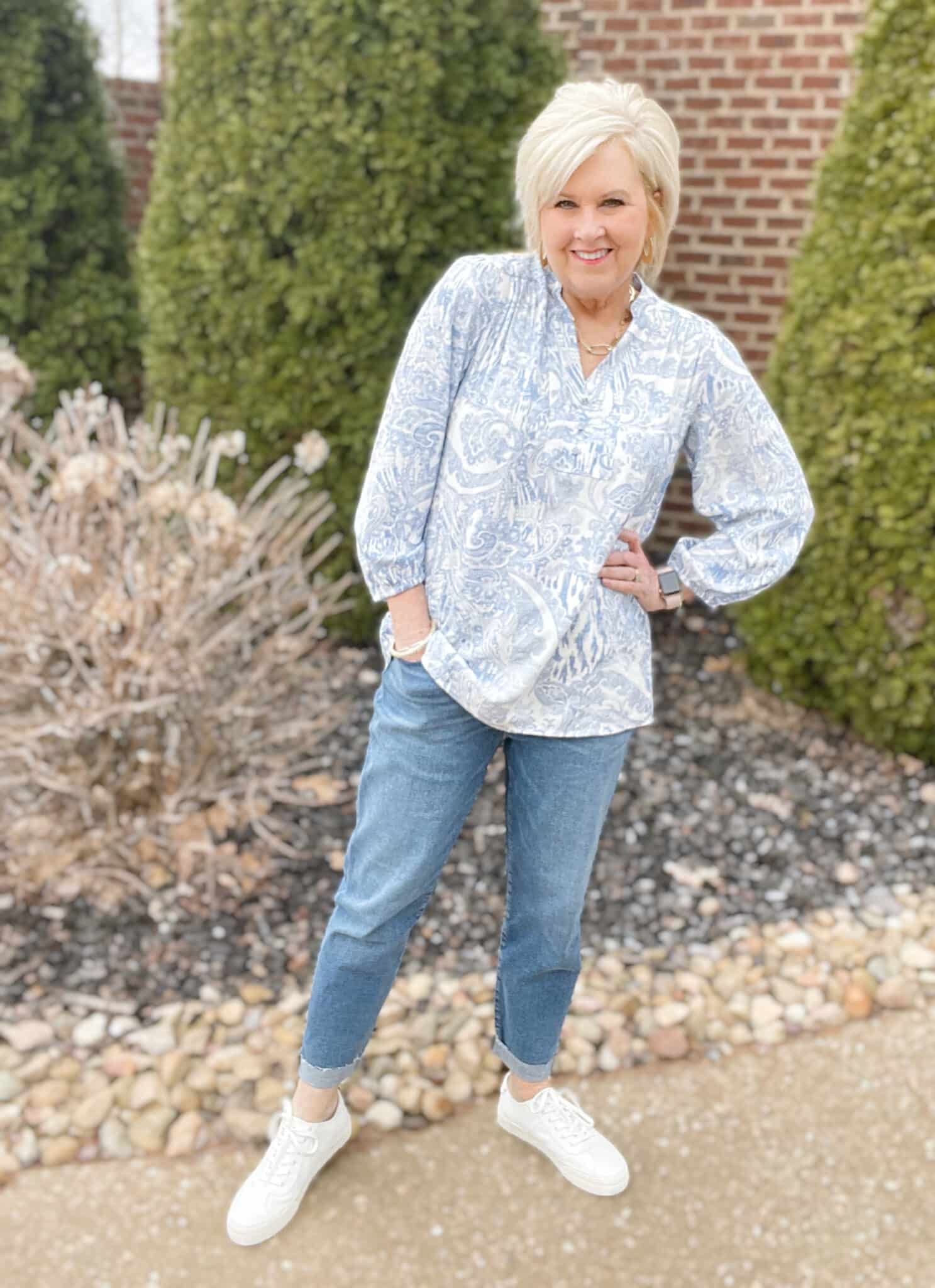 Over 40 Fashion Blogger, Tania Stephens is wearing a blue print blouse with relaxed jeans and white sneakers