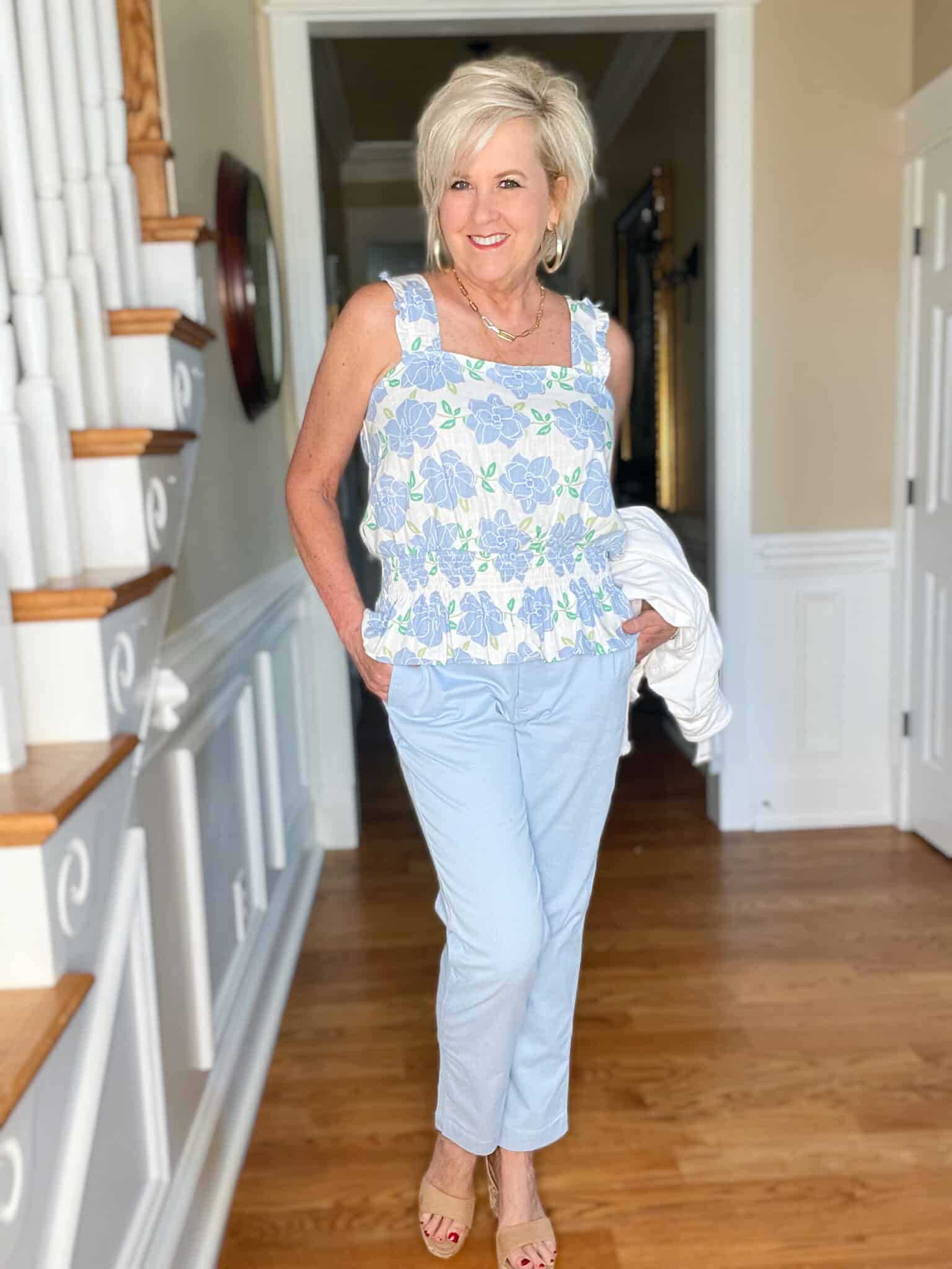 Over 40 Fashion Blogger, Tania Stephens is wearing a Kohl's top, a white jacket, blue pants, and neutral wedges1