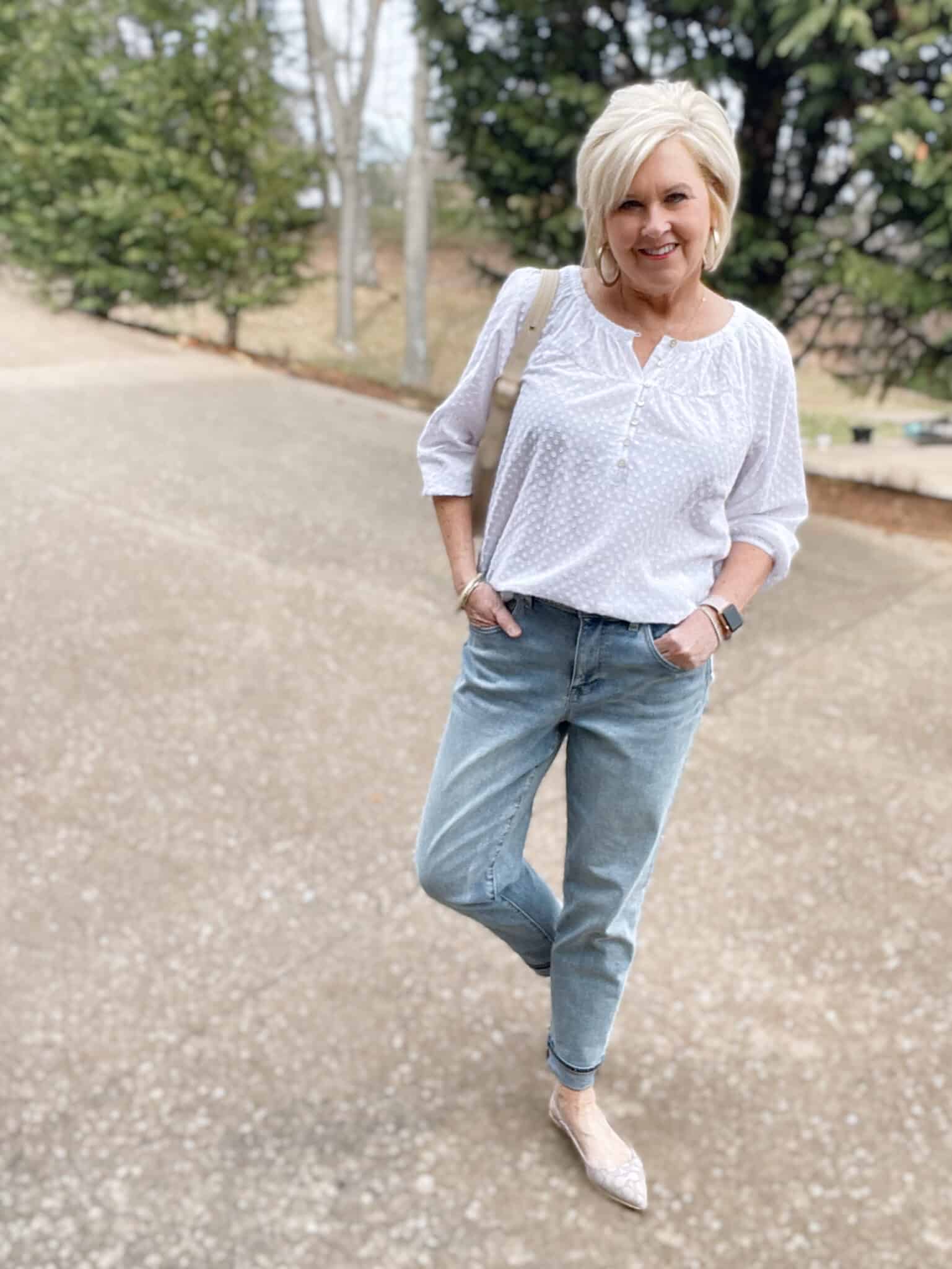 Over 40 Fashion Blogger, Tania Stephens is styling a white henley blouse with light wash jeans