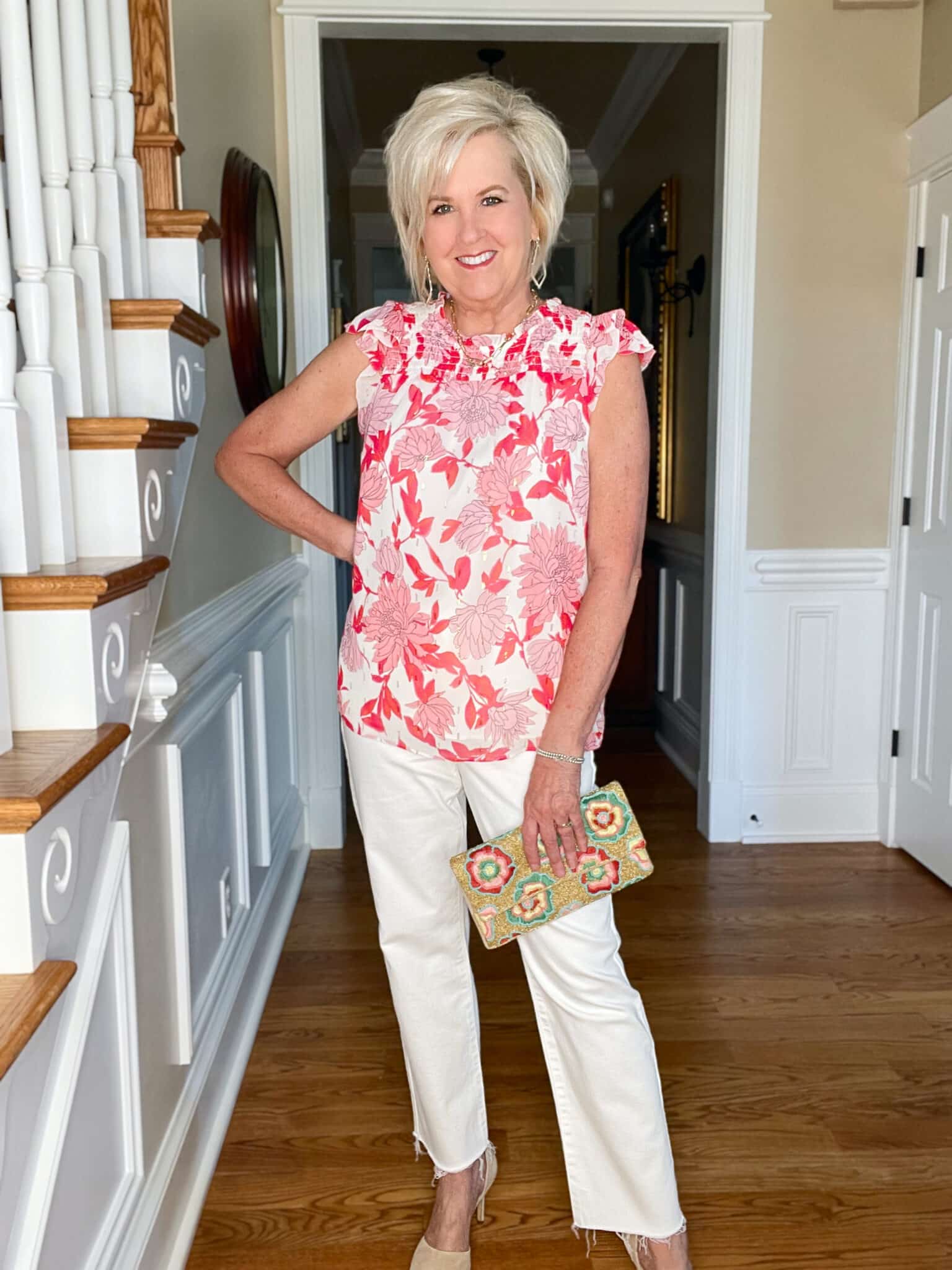 Over 40 Fashion Blogger, Tania Stephens is wearing a pink and white floral top with white jeans and neutral heels