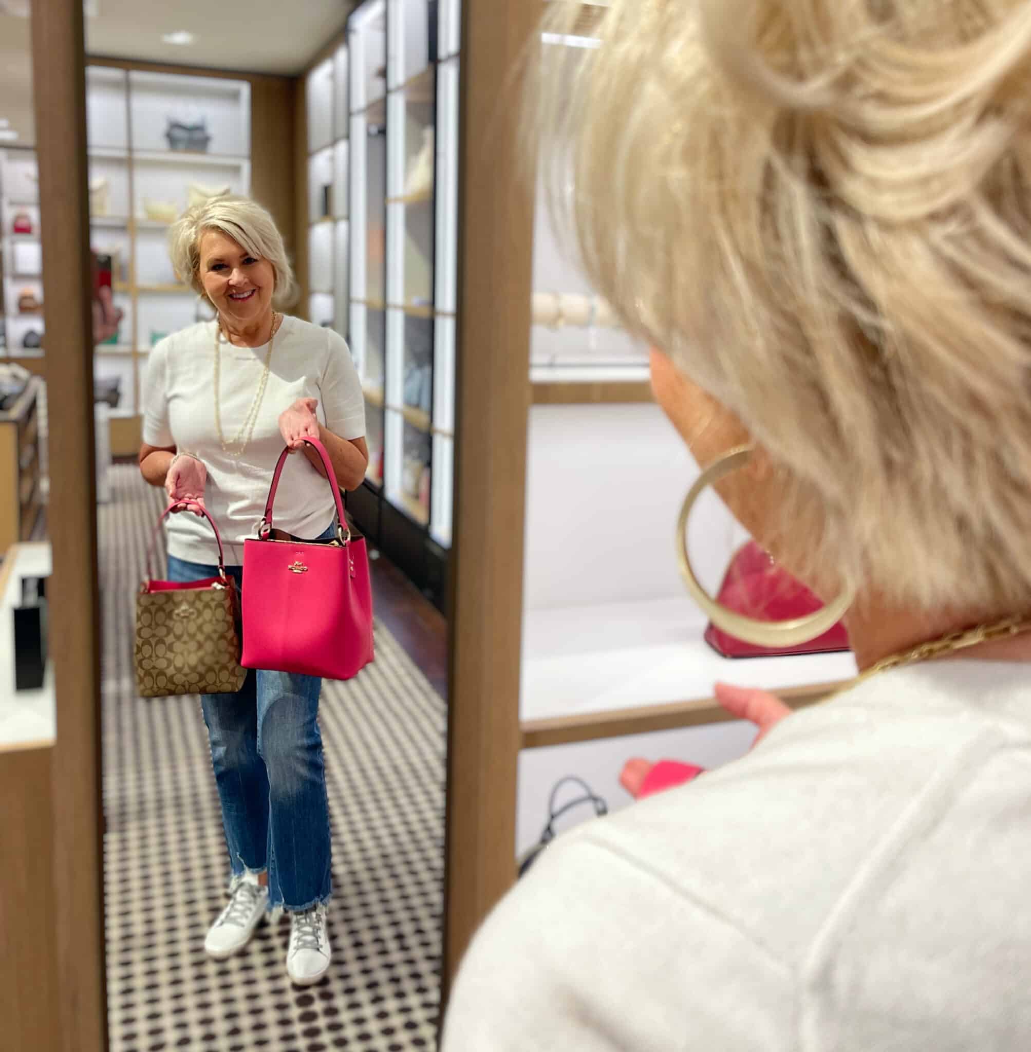 Over 40 Fashion Blogger, Tania Stephens is shopping for a pink handbag at Coach Outlet in Asheville, NC