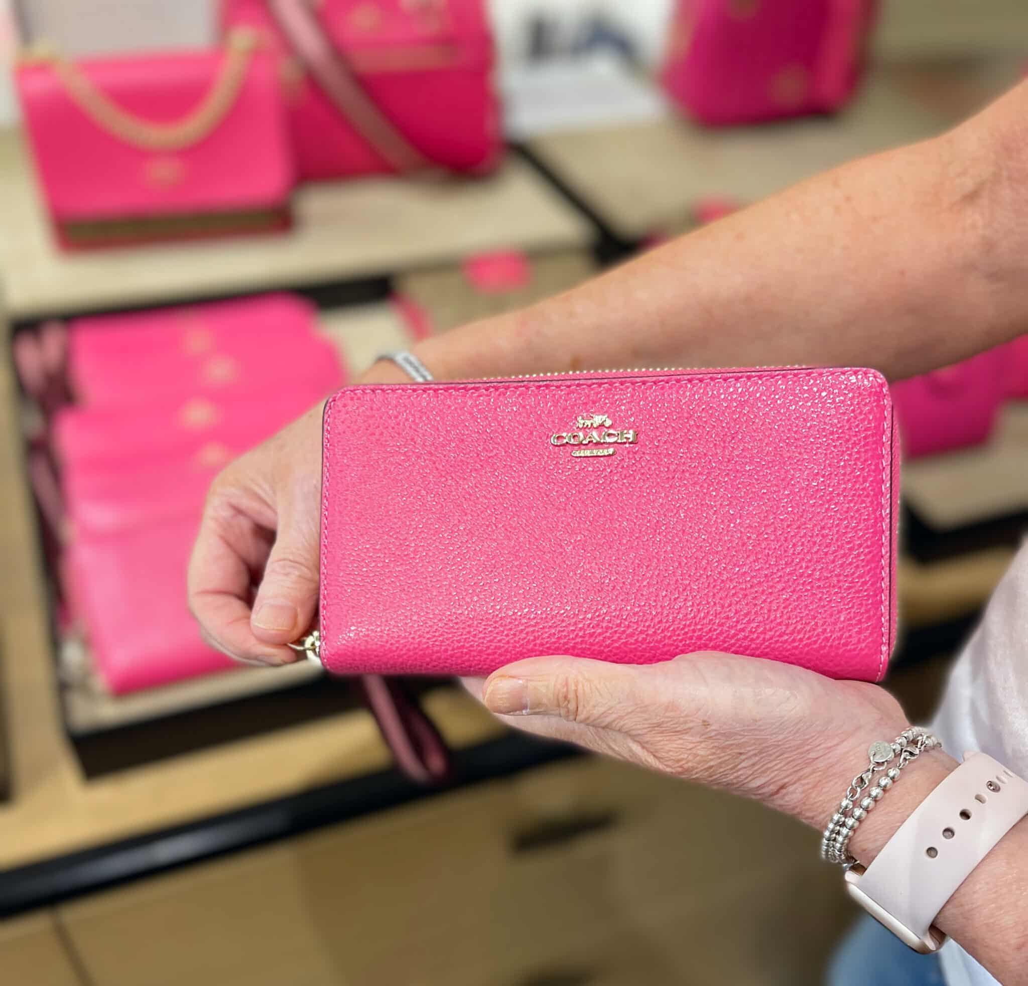 Over 40 Fashion Blogger, Tania Stephens is shopping for a pink wallet at Coach Outlet in Asheville, NC