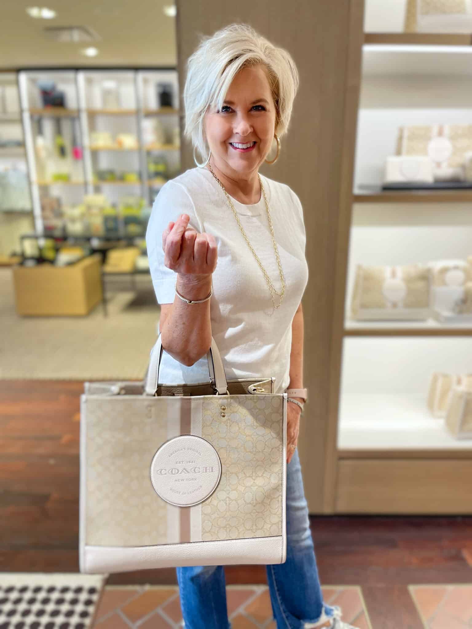 Over 40 Fashion Blogger, Tania Stephens is shopping for a large tote handbag at Coach Outlet in Asheville, NC