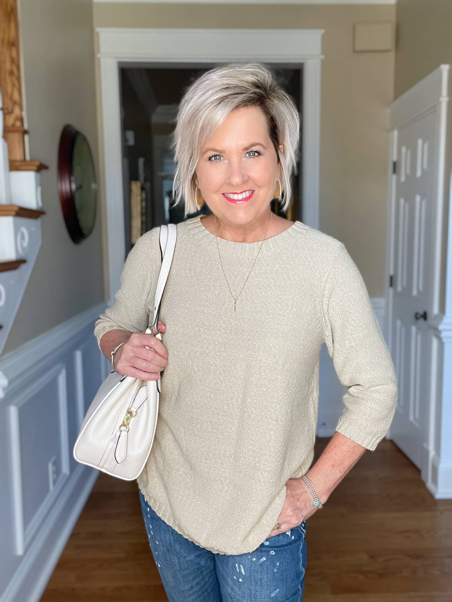 Over 40 Fashion Blogger, Tania Stephens is wearing a beige sweater with paint splattered jeans