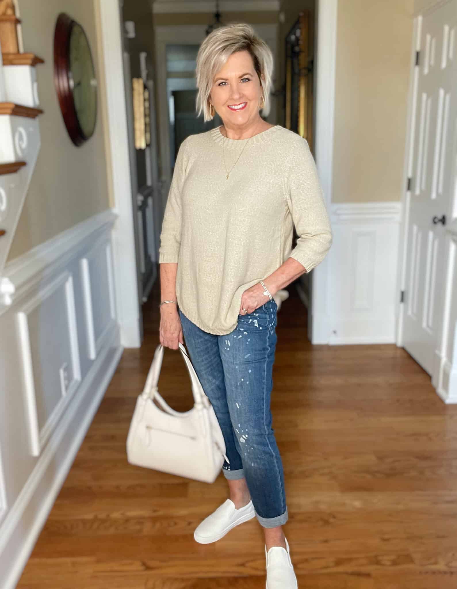 Over 40 Fashion Blogger, Tania Stephens is wearing a beige sweater with paint splattered jeans 5
