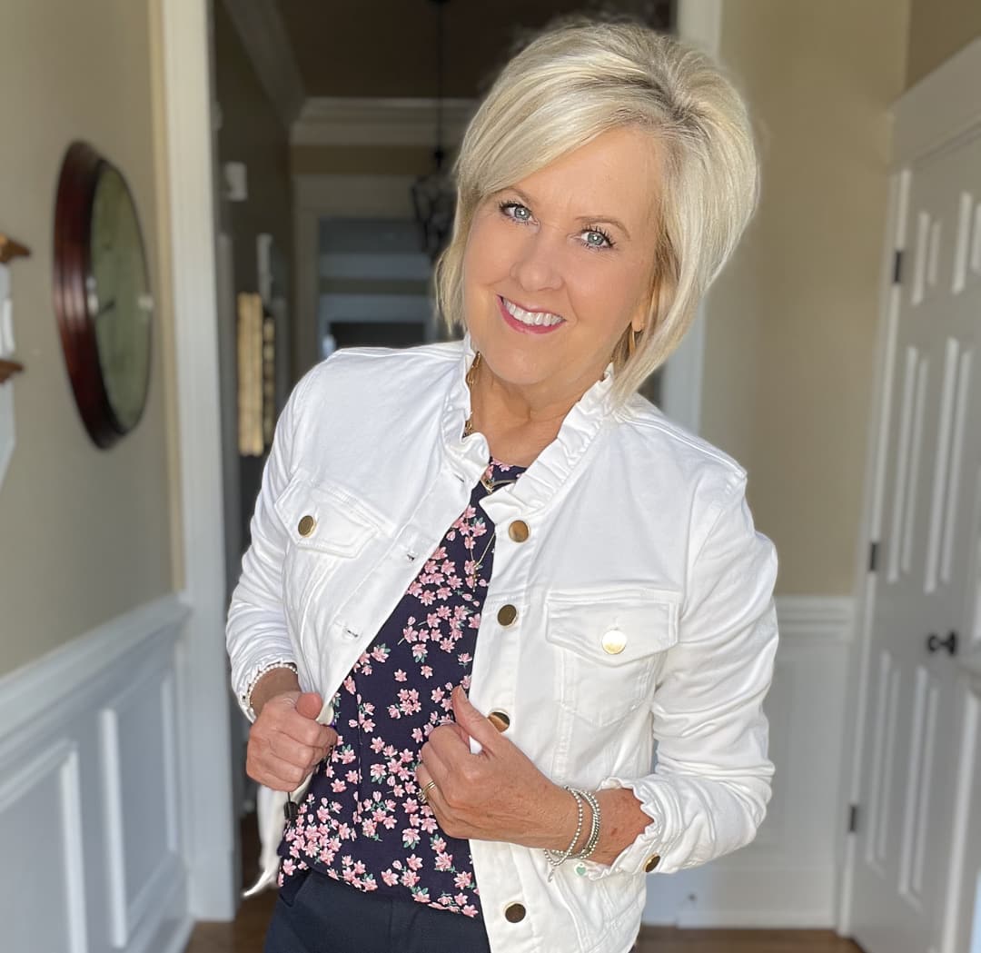 Over 40 Fashion Blogger, Tania Stephens is wearing navy crop pants, a printed top, and a white denim jacket 10
