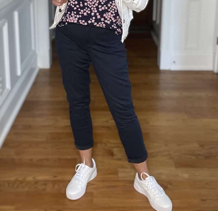 Over 40 Fashion Blogger, Tania Stephens is wearing navy crop pants, a printed top, and a white denim jacket 3