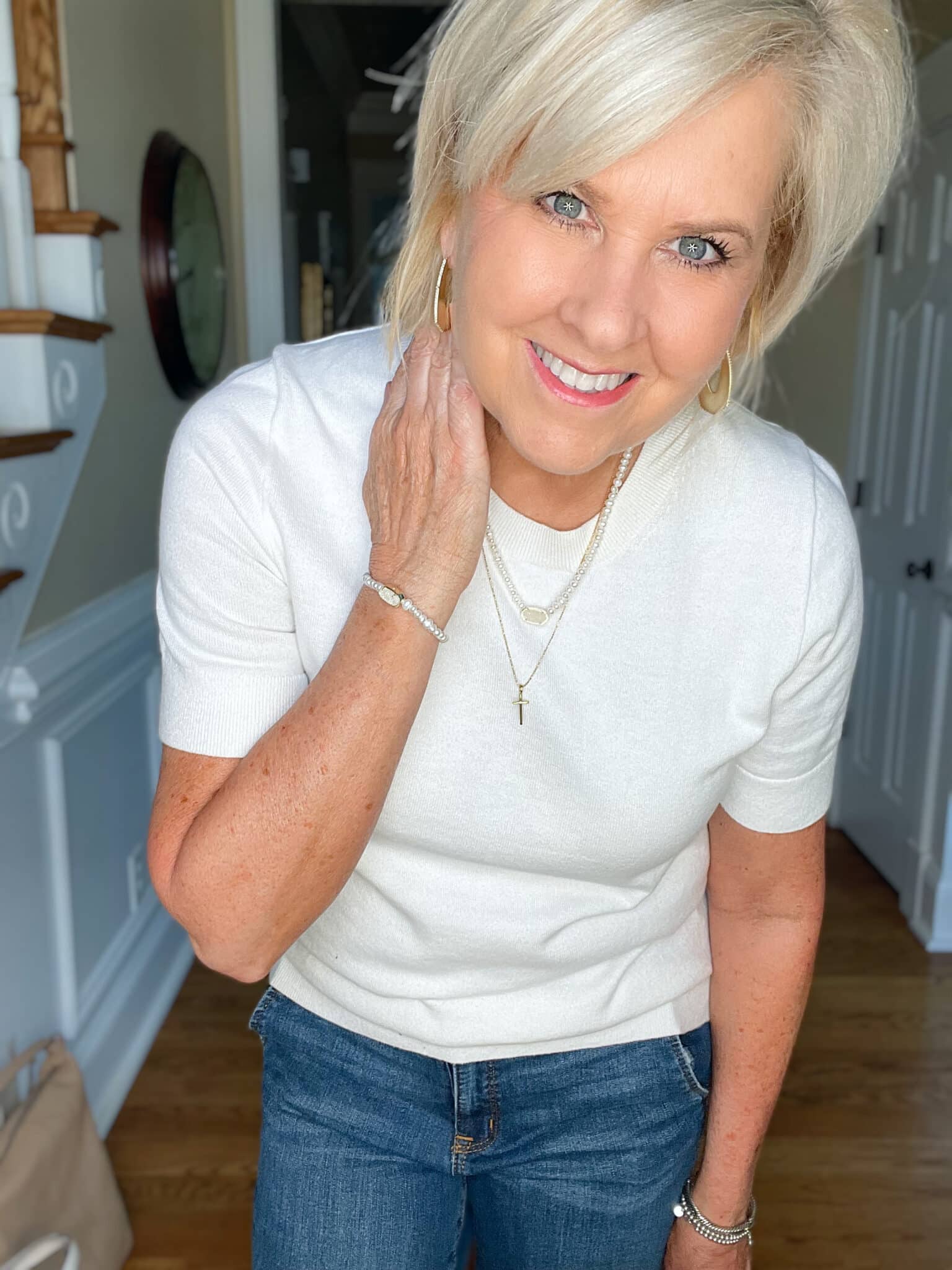 Over 40 Fashion Blogger, Tania Stephens is wearing a white cashmere blend tee, straight cut jeans, a navy double breasted blazer, and carrying a neutral handbag 14