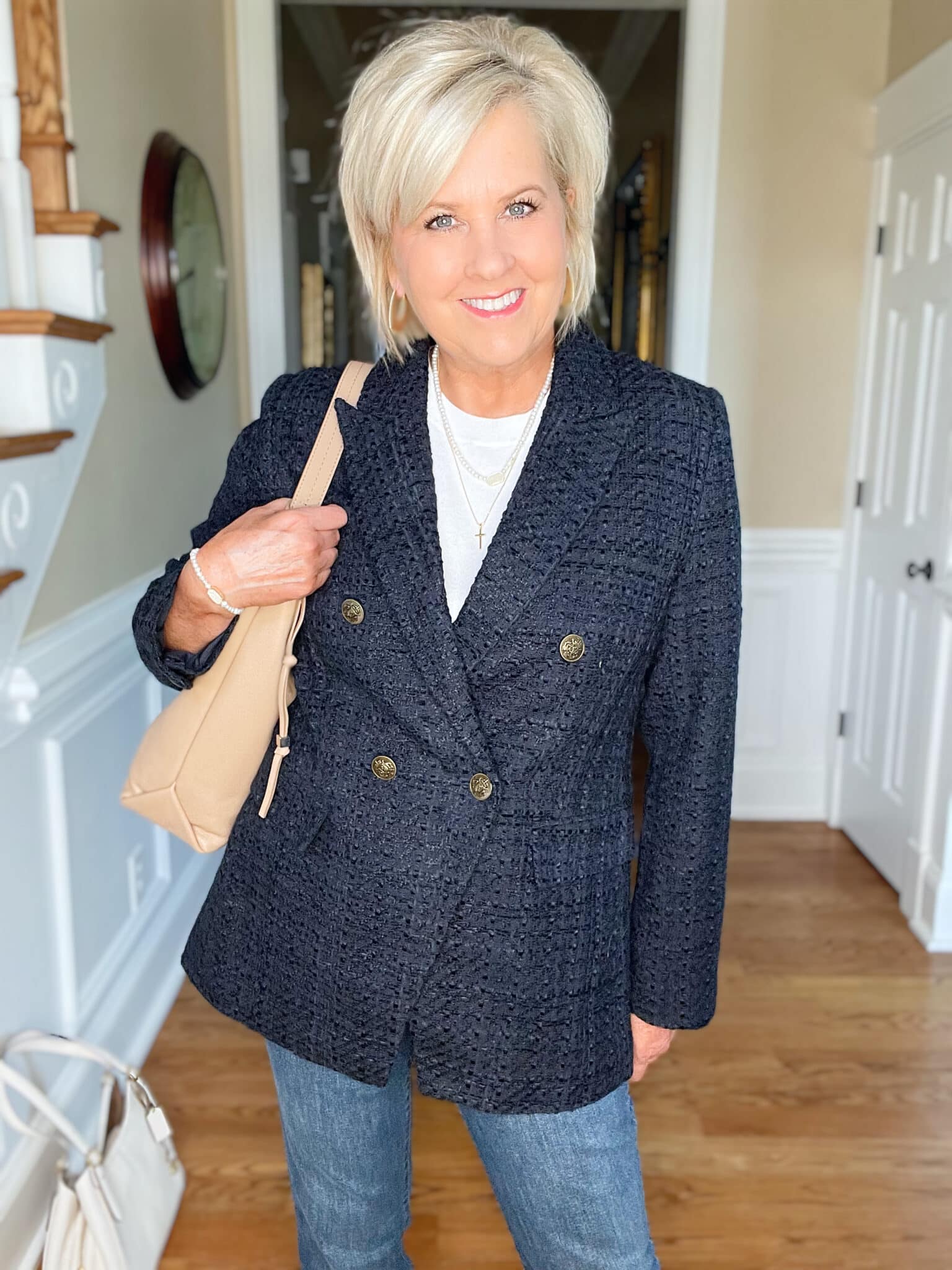 Over 40 Fashion Blogger, Tania Stephens is wearing a white cashmere blend tee, straight cut jeans, a navy double breasted blazer, and carrying a neutral handbag 23