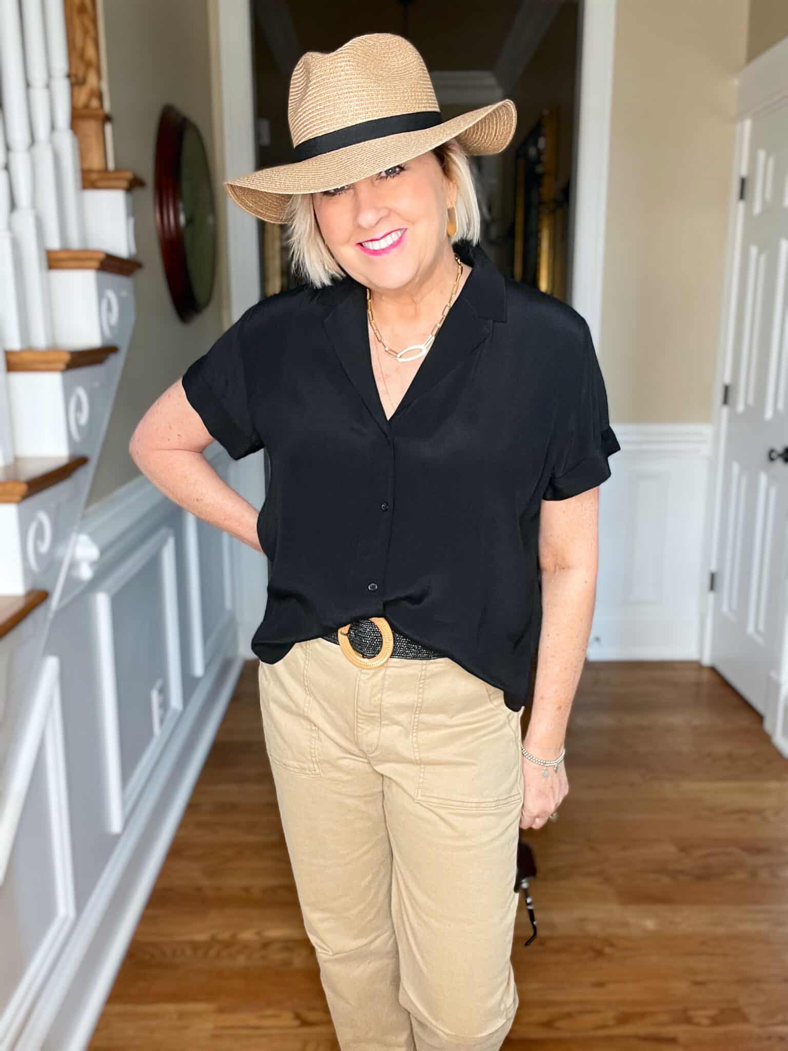 Over 40 Fashion Blogger, Tania Stephens is wearing a black short sleeve shirt with tan pants and a straw fedora1