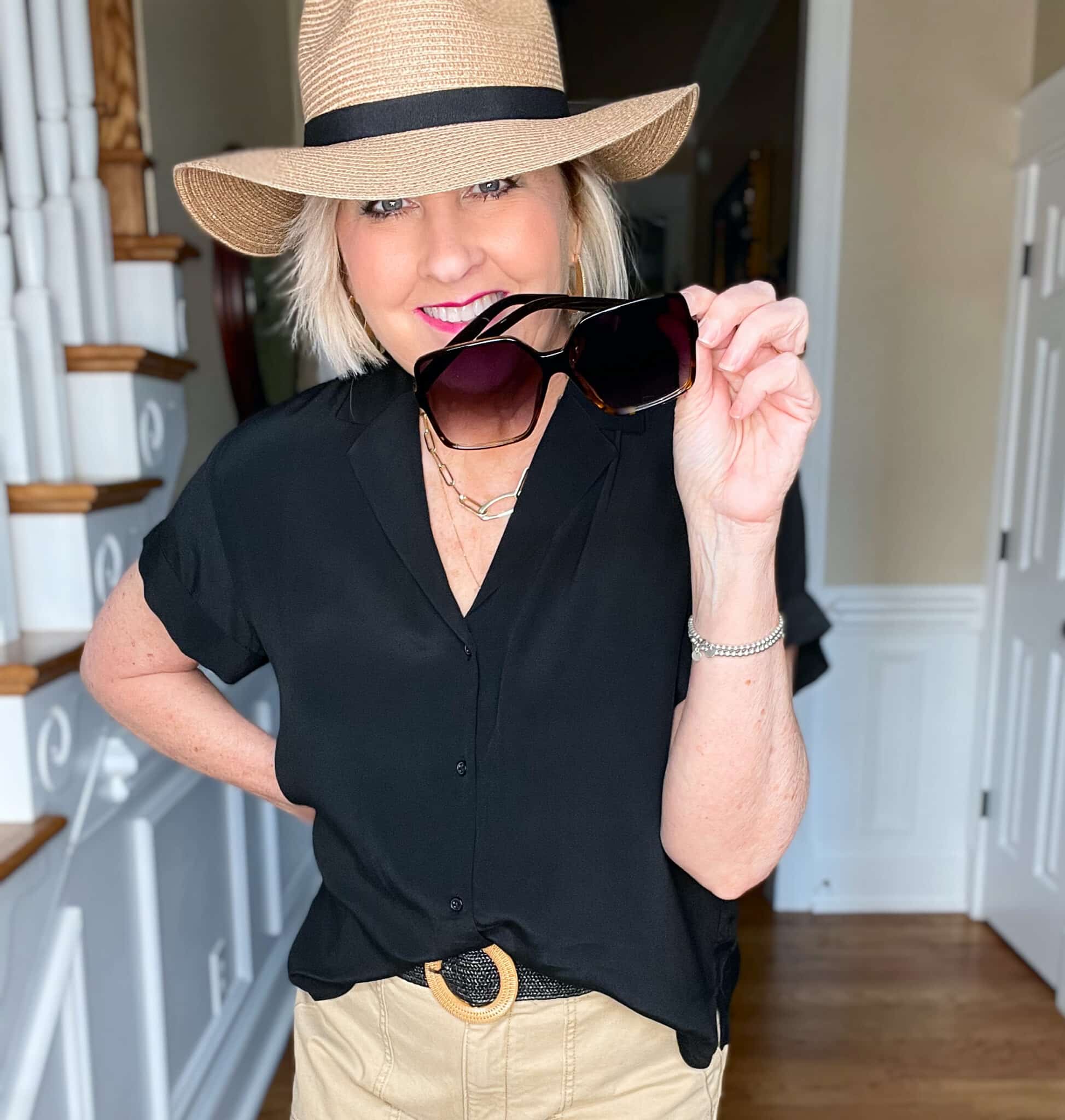 Over 40 Fashion Blogger, Tania Stephens is wearing a black short sleeve shirt with tan pants and a straw fedora11