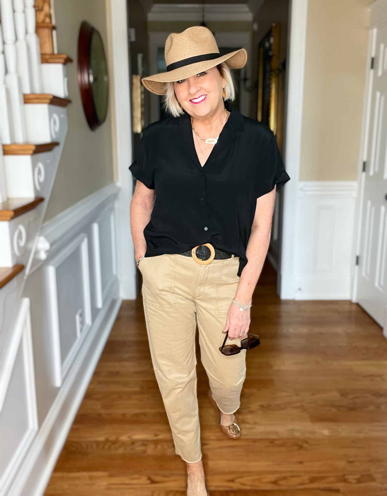 Over 40 Fashion Blogger, Tania Stephens is wearing a black short sleeve shirt with tan pants and a straw fedora13