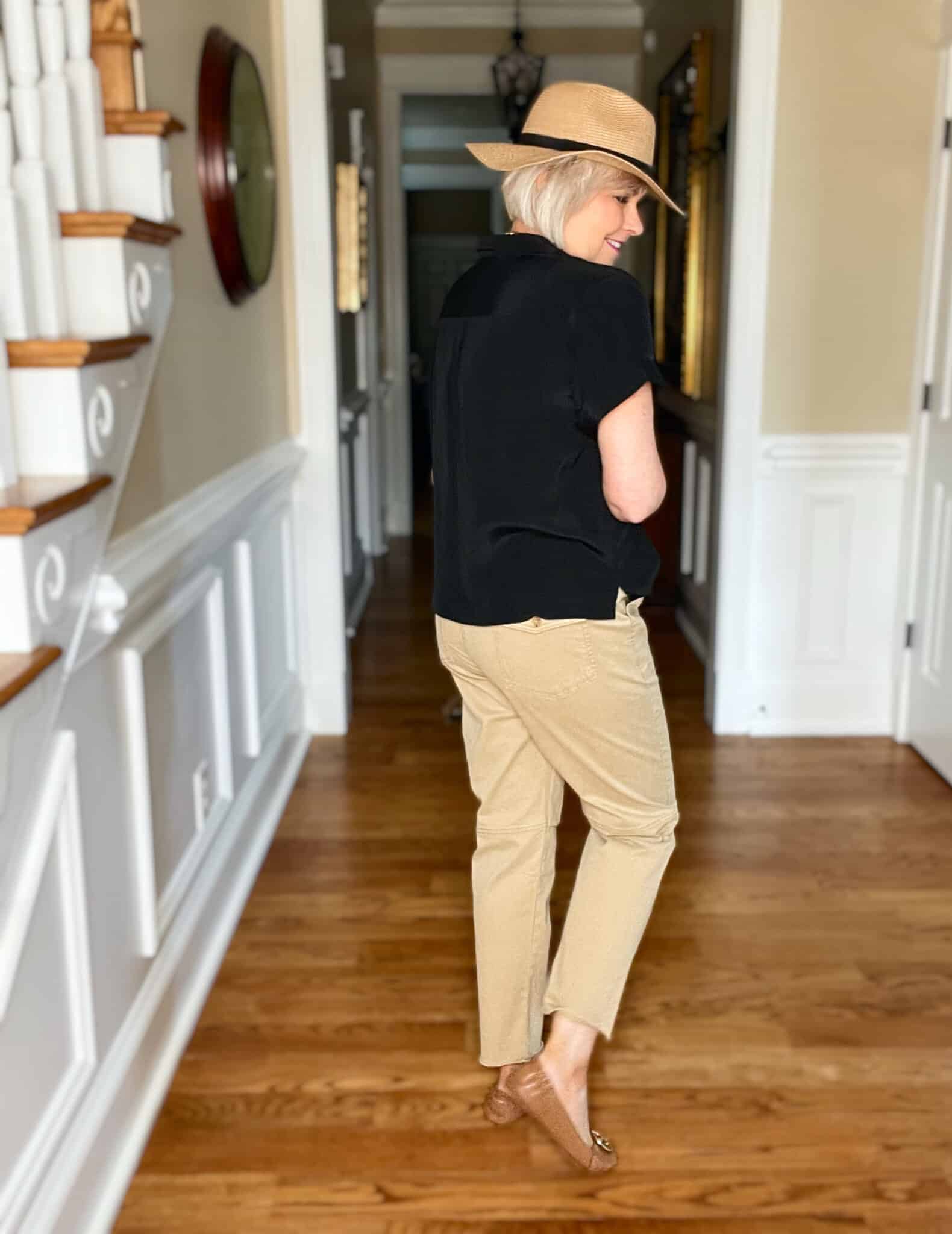 Over 40 Fashion Blogger, Tania Stephens is wearing a black short sleeve shirt with tan pants and a straw fedora7