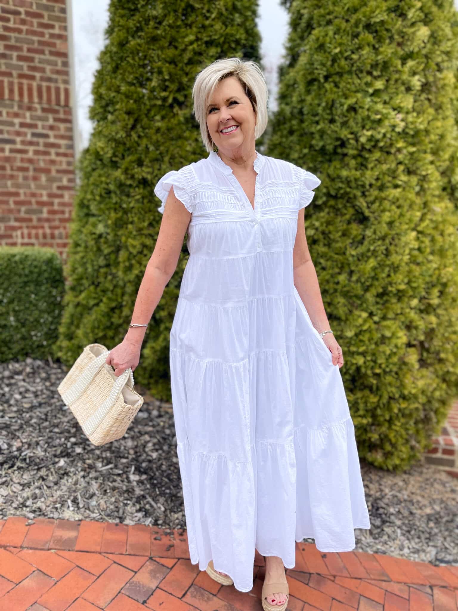 Over 40 Fashion Blogger, Tania Stephens is keeping wearing a white tiered maxi dress with a straw bag 10