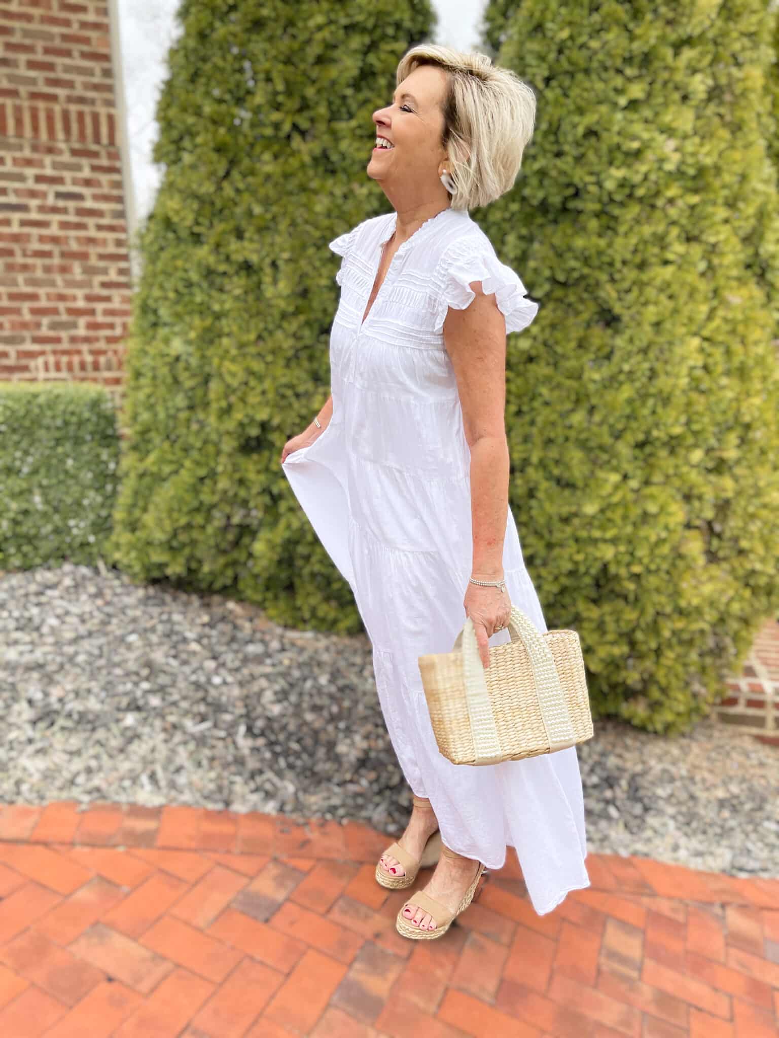 Over 40 Fashion Blogger, Tania Stephens is keeping wearing a white tiered maxi dress with a straw bag 2