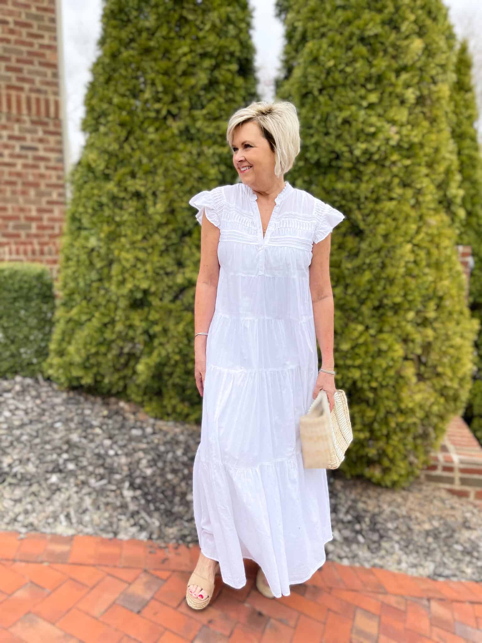 Over 40 Fashion Blogger, Tania Stephens is keeping wearing a white tiered maxi dress with a straw bag 13