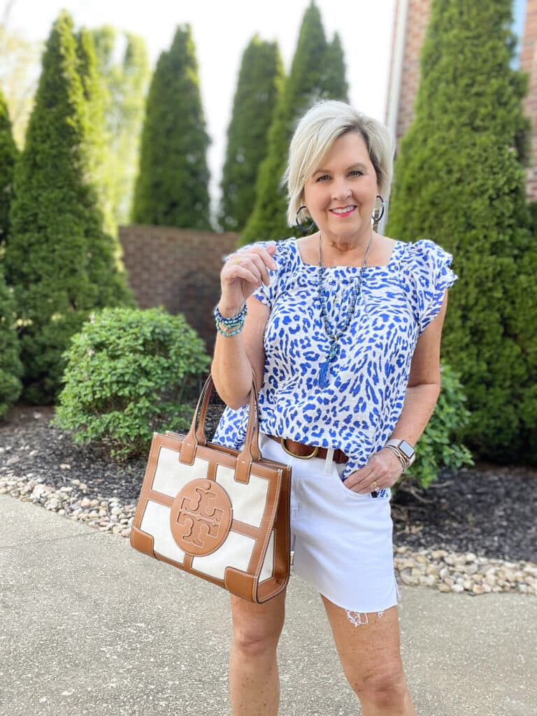 Over 40 Fashion Blogger, Tania Stephens is wearing a flutter sleeve top with white shorts and blue jewelry 32