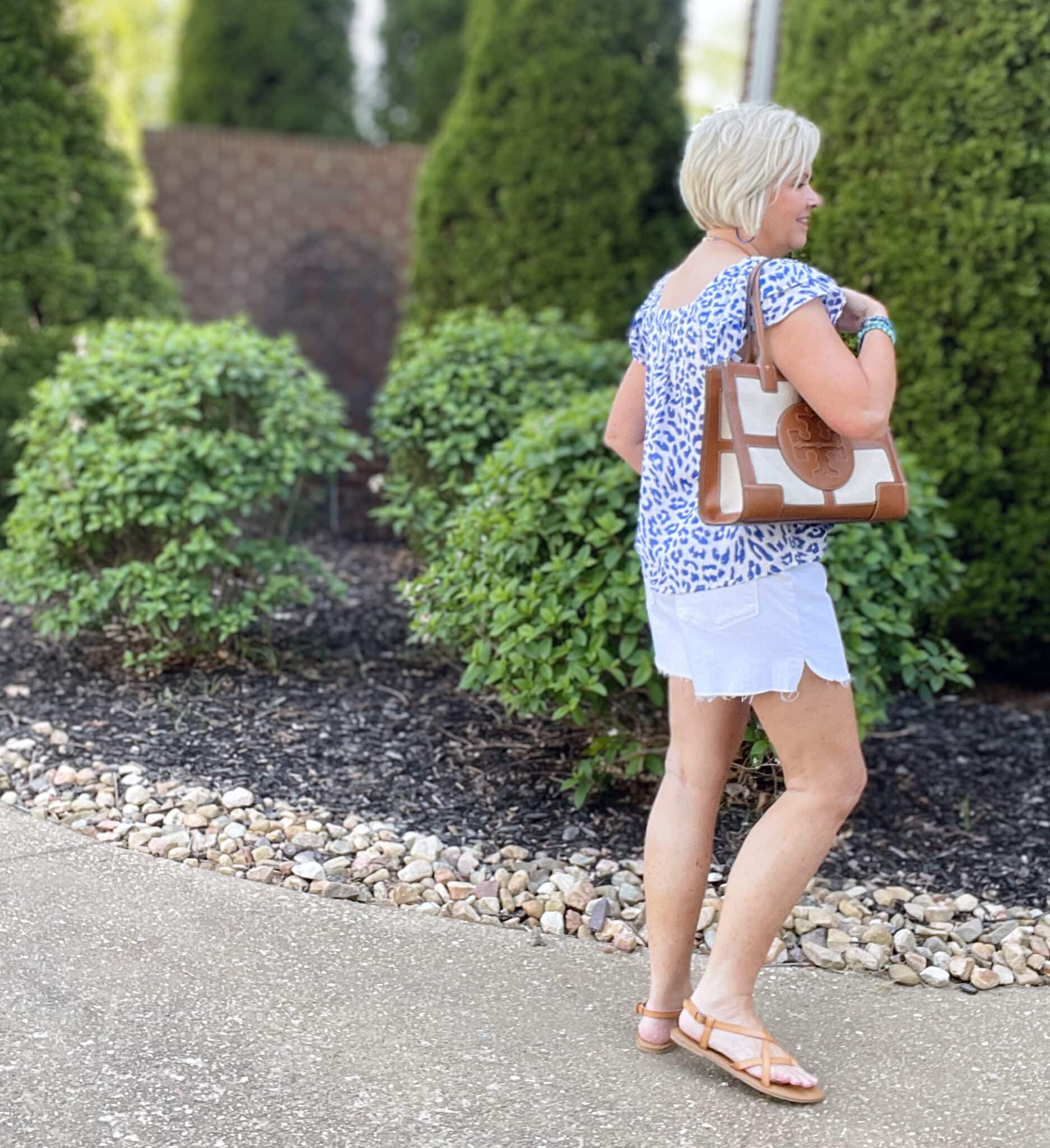 Over 40 Fashion Blogger, Tania Stephens is wearing a flutter sleeve top with white shorts and blue jewelry33
