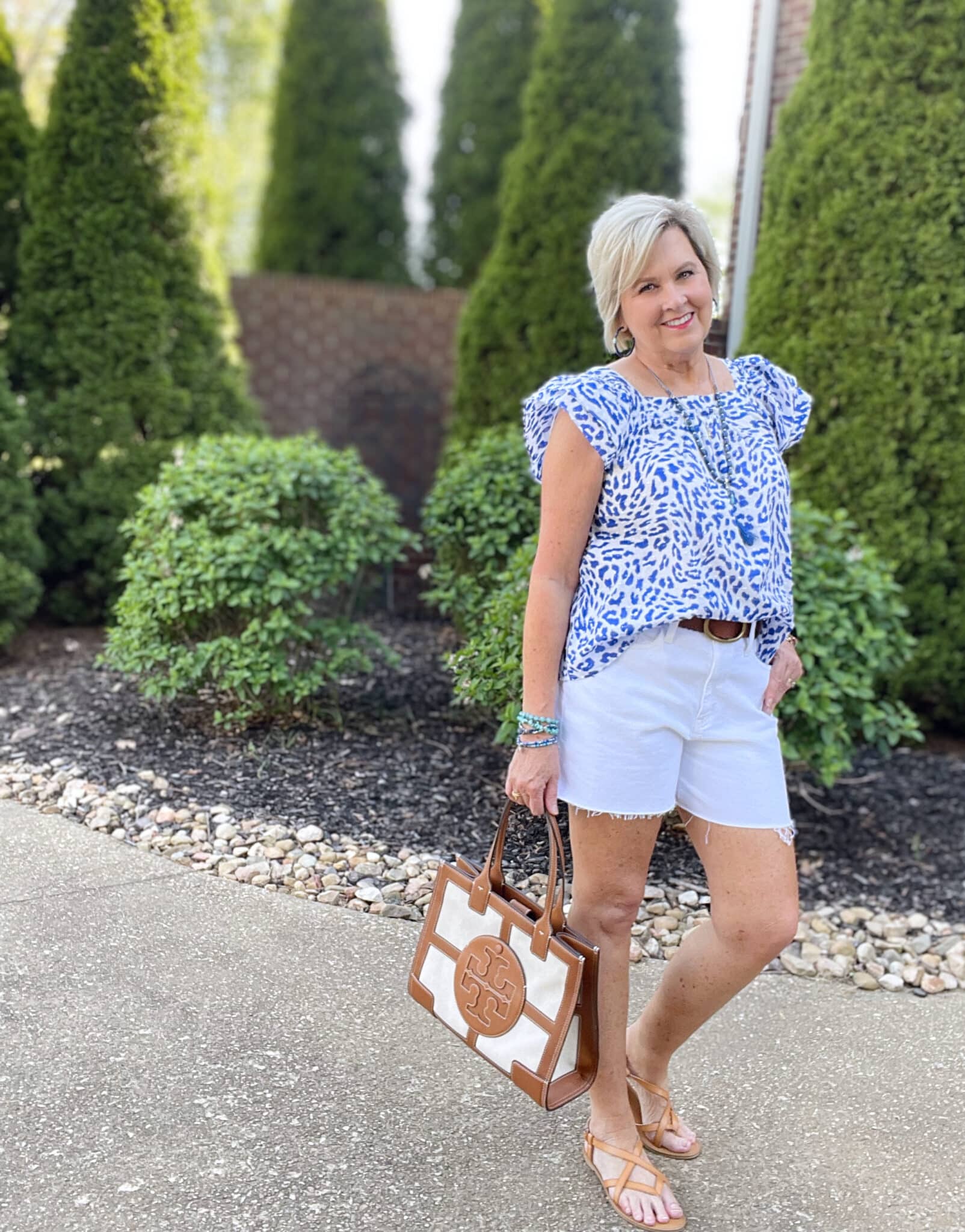 Over 40 Fashion Blogger, Tania Stephens is wearing a flutter sleeve top with white shorts and blue jewelry36
