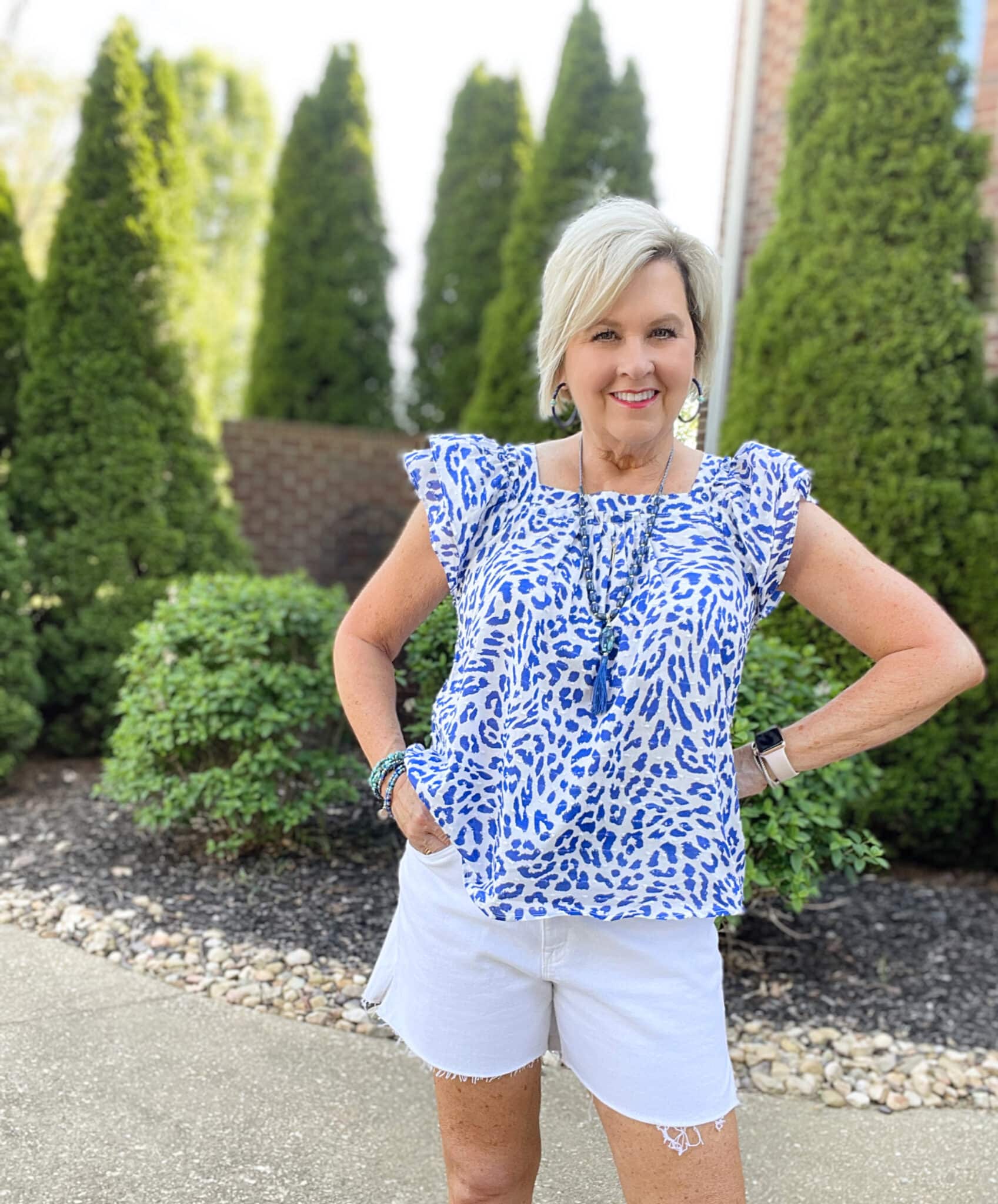 Over 40 Fashion Blogger, Tania Stephens is wearing a flutter sleeve top with white shorts and blue jewelry38