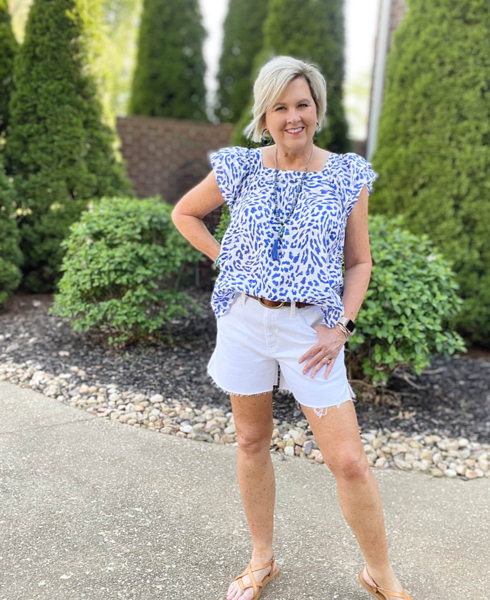 Over 40 Fashion Blogger, Tania Stephens is wearing a flutter sleeve top with white shorts and blue jewelry 47