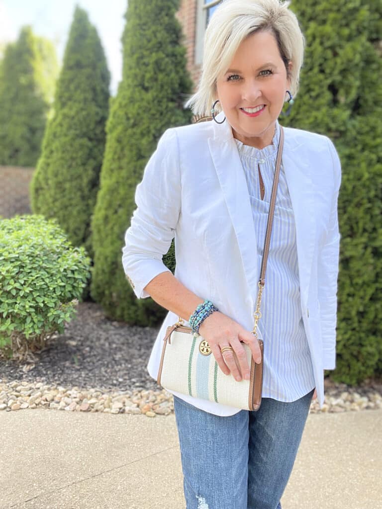 Over 40 Fashion Blogger, Tania Stephens is wearing a striped blouse, a white linen blazer, and distressed jeans 5