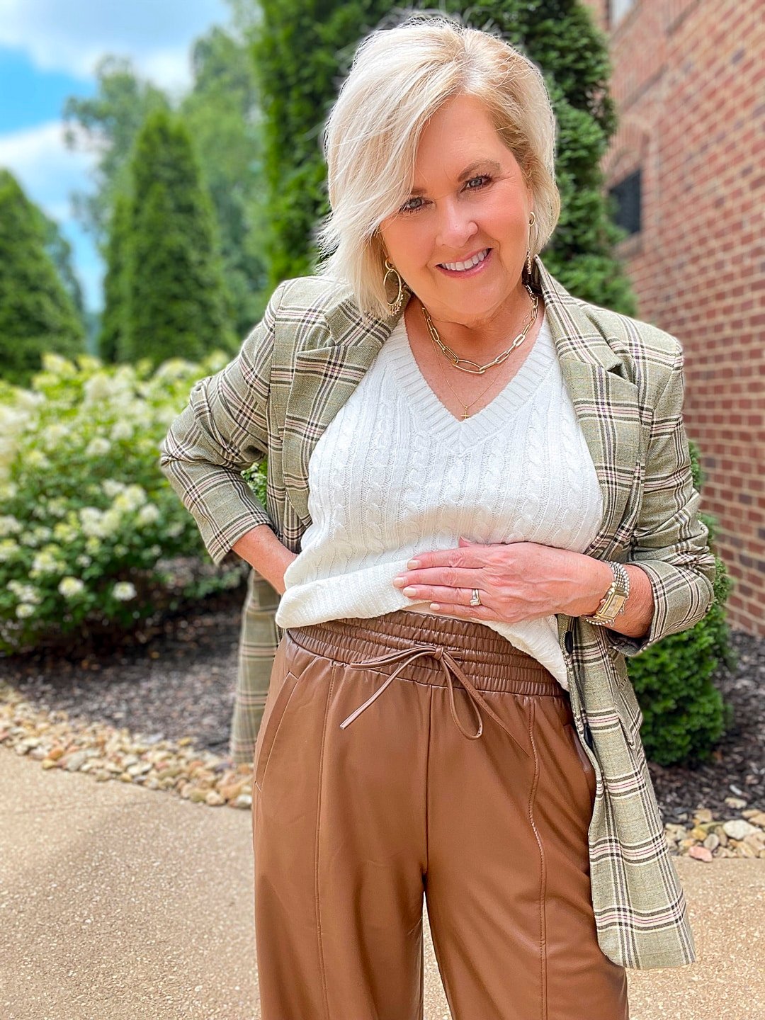 Over 40 Fashion Blogger, Tania Stephens is styling brown faux leather wide leg pant with a cream sweater and a plaid blazer11