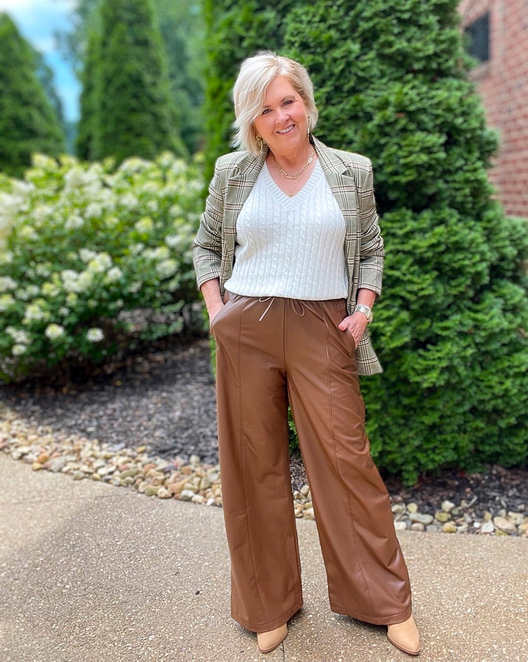 Over 40 Fashion Blogger, Tania Stephens is styling brown faux leather wide leg pant with a cream sweater and a plaid blazer 9