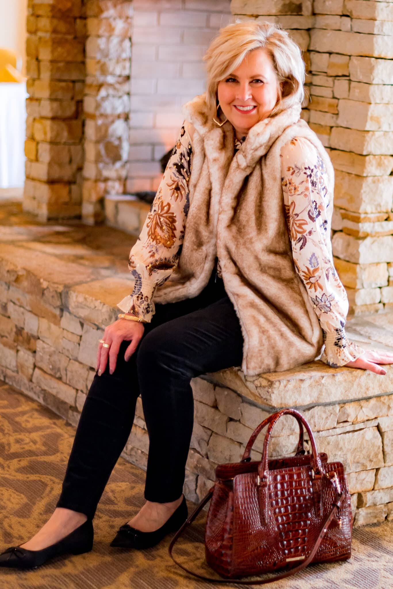 Over 40 Fashion Blogger, Tania Stephens is wearing a leaf print blouse with a fur vest and black pants1049