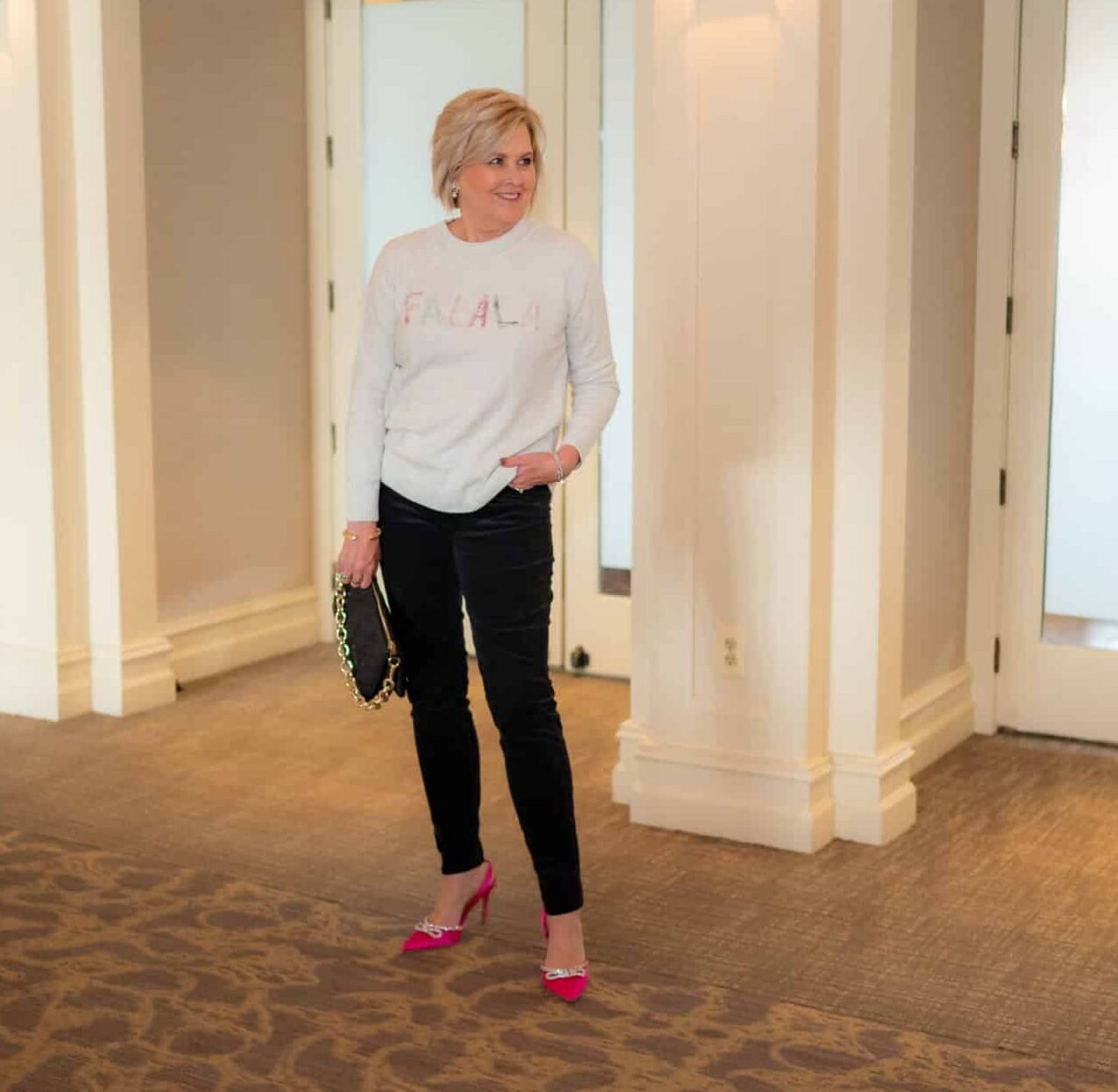 Over 40 Fashion Blogger, Tania Stephens is wearing a Christmas sweater with black jeans and pink heels 1153