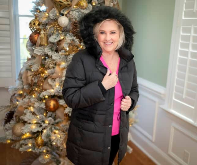 Over 40 Fashion Blogger, Tania Stephens is wearing a pink sweater with black pants and a black coat with fur trim3