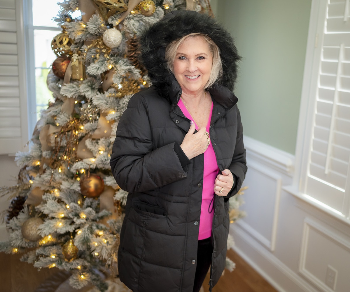 Over 40 Fashion Blogger, Tania Stephens is wearing a pink sweater with black pants and a black coat with fur trim3