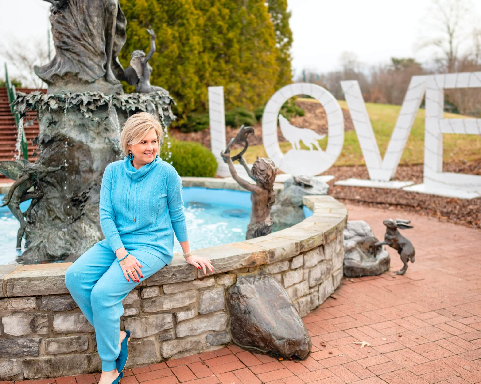 Over 40 Fashion Blogger, Tania Stephens is wearing a turquoise sweater and jogger set from Chico's 