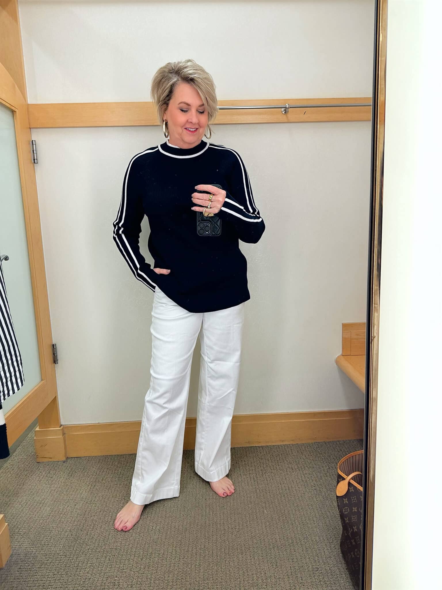 Tania Stephens from 50 Is Not Old is styling a tied black and white sweater with white wide leg pants from Talbots 