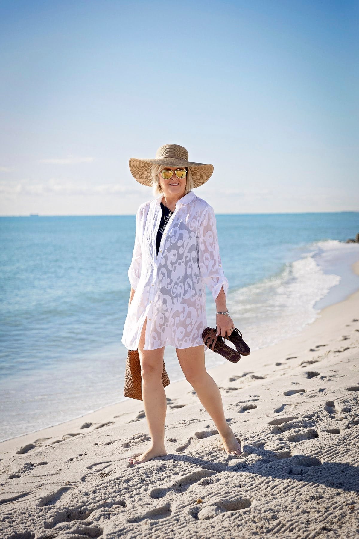 Fashion Blogger, Tania Stephens is wearing a miraclesuit swimsuit with a white coverup and sporting a faux tan