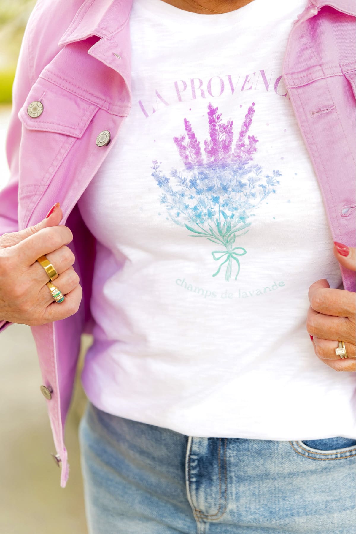 Tania Stephens is leaning on a stone post wearing a lilac denim jacket and straight leg jeans from Talbots6