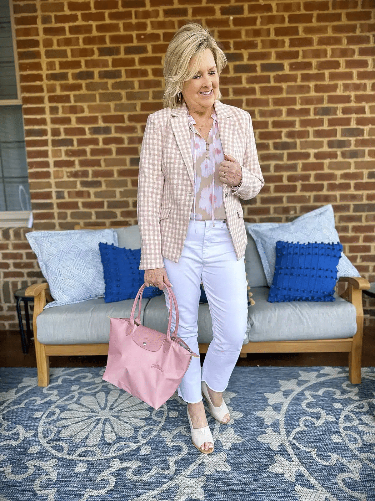 Tania Stephens is wearing white jeans with a plaid blazer.