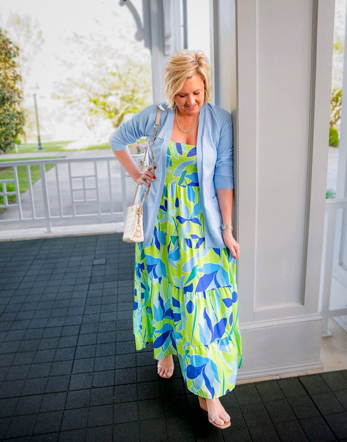 Woman wearing a colorful blue and green floral maxi dress with a light blue cardigan – best summer maxi dresses for women over 50